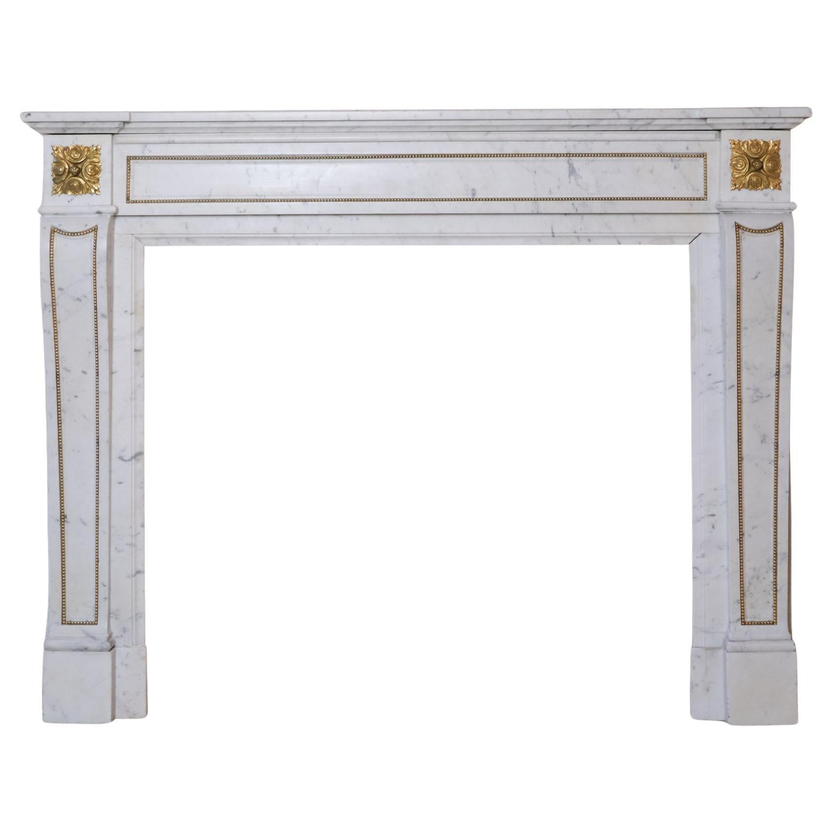 19th Century Mantelpiece of white Carrara marble with fire-gilded decorations