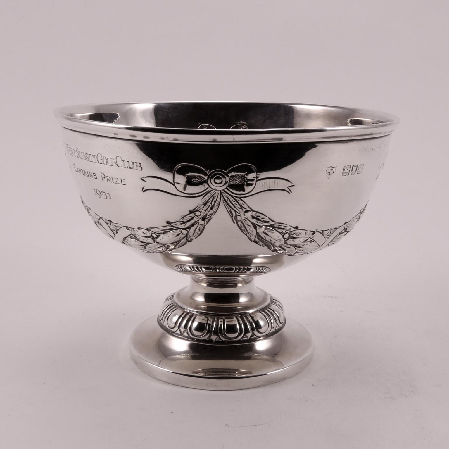 Rare 1896 cup, decorated with charming bows, produced by Mappin & Webb for F.G.L. F Aire and won by A.E.R. Gilligan. An historical moment of glory, impressed in the silver. Now it can be yours, after 120 years.