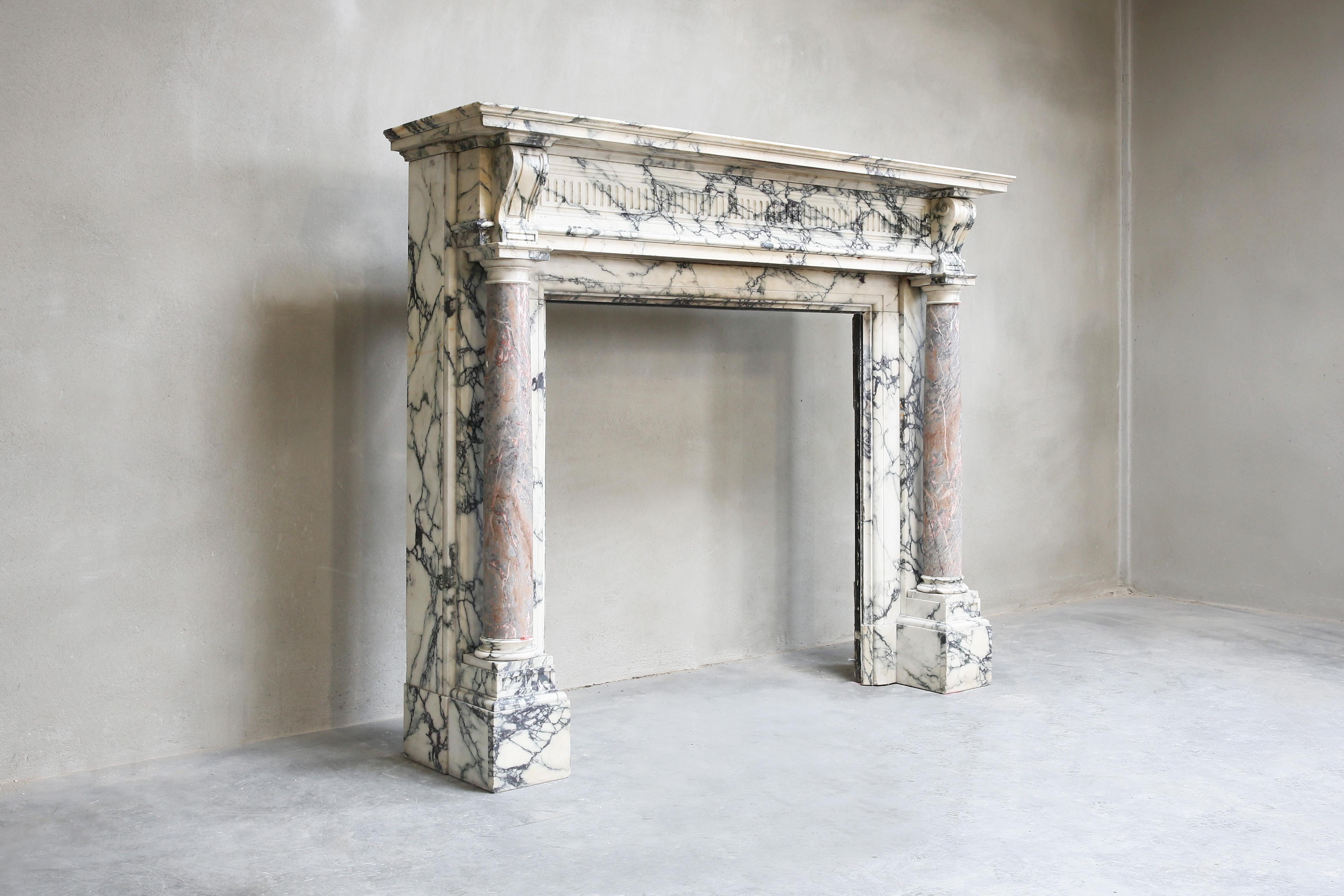 We are proud to present this beautiful antique marble fireplace! A treasure in our collection. This fireplace is made from two exclusive types of marble: the largest part consists of Paonazzo marble and the two pillars on the legs are equipped with