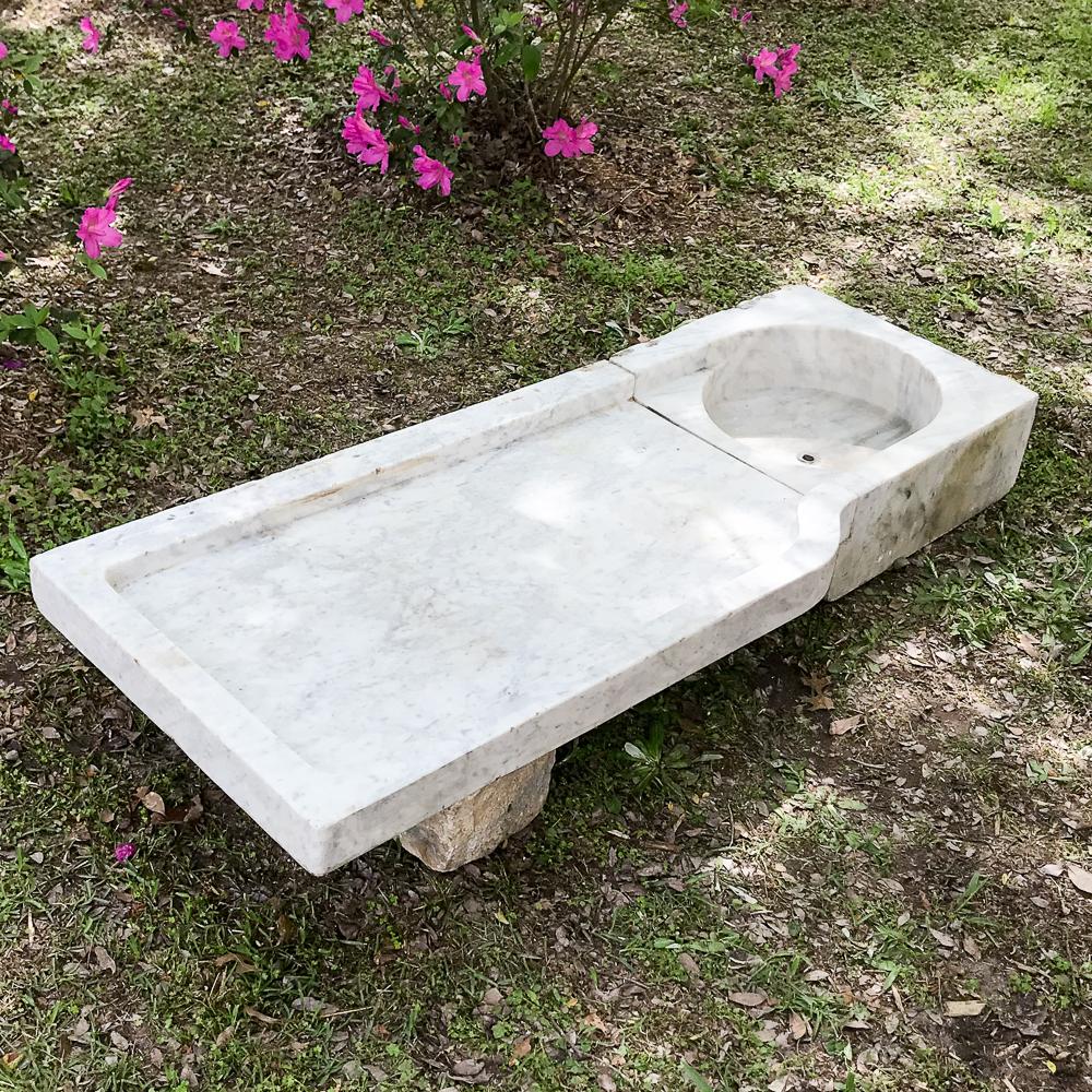 19th century marble fountain basin or garden sink was handcut from solid Carrara marble into two pieces, a basin with drain and a flange that drains to the basin. Ideal for the base of a fountain, or to elevate and use as a garden sink. Virtually