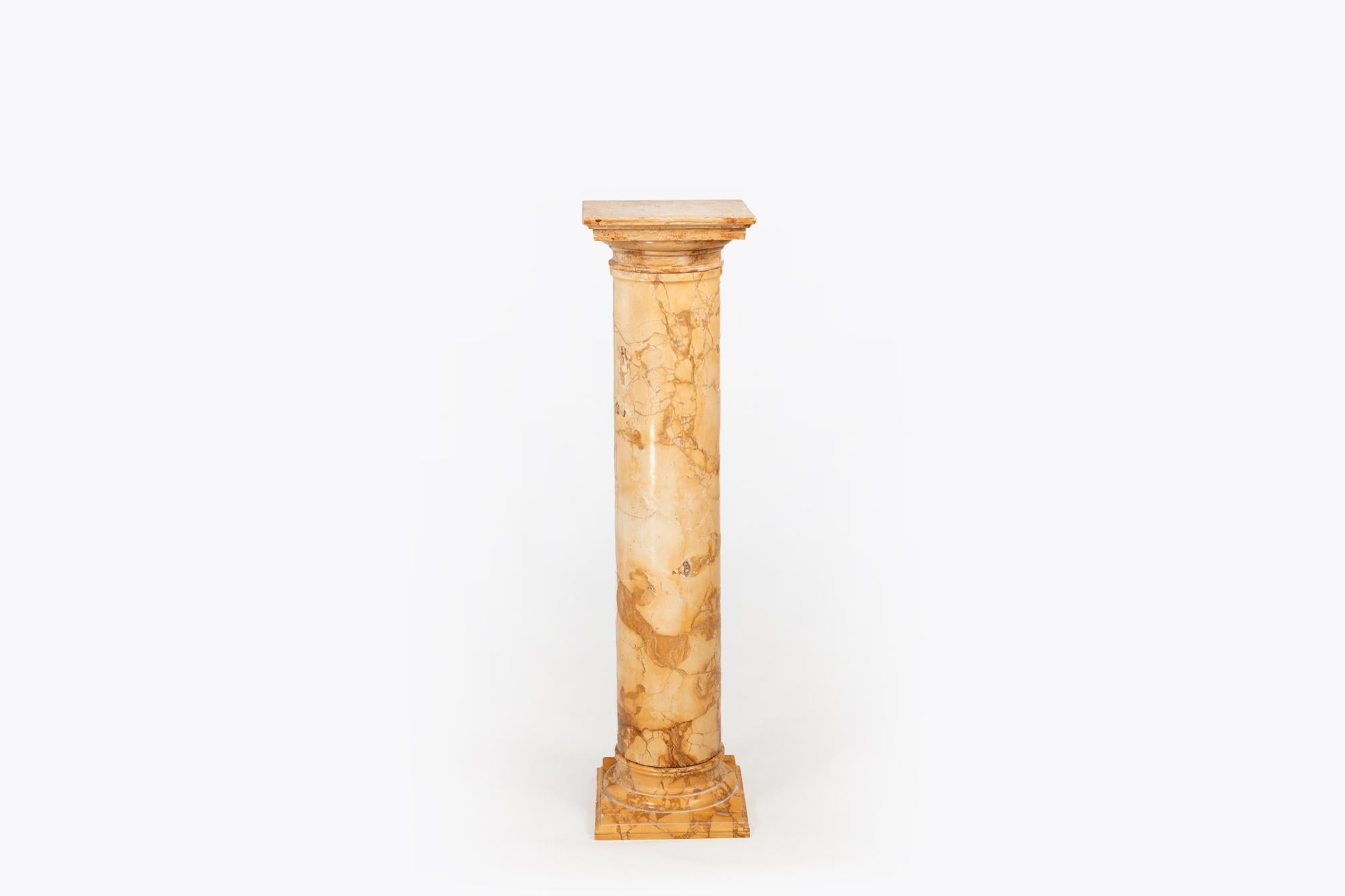 Socle en marbre du 19e siècle en forme de colonne classique. Le fût cylindrique massif en marbre jaune et ocre repose sur une base carrée à gradins et est surmonté d'une plaque de marbre carrée reposant sur le sommet de la colonne.