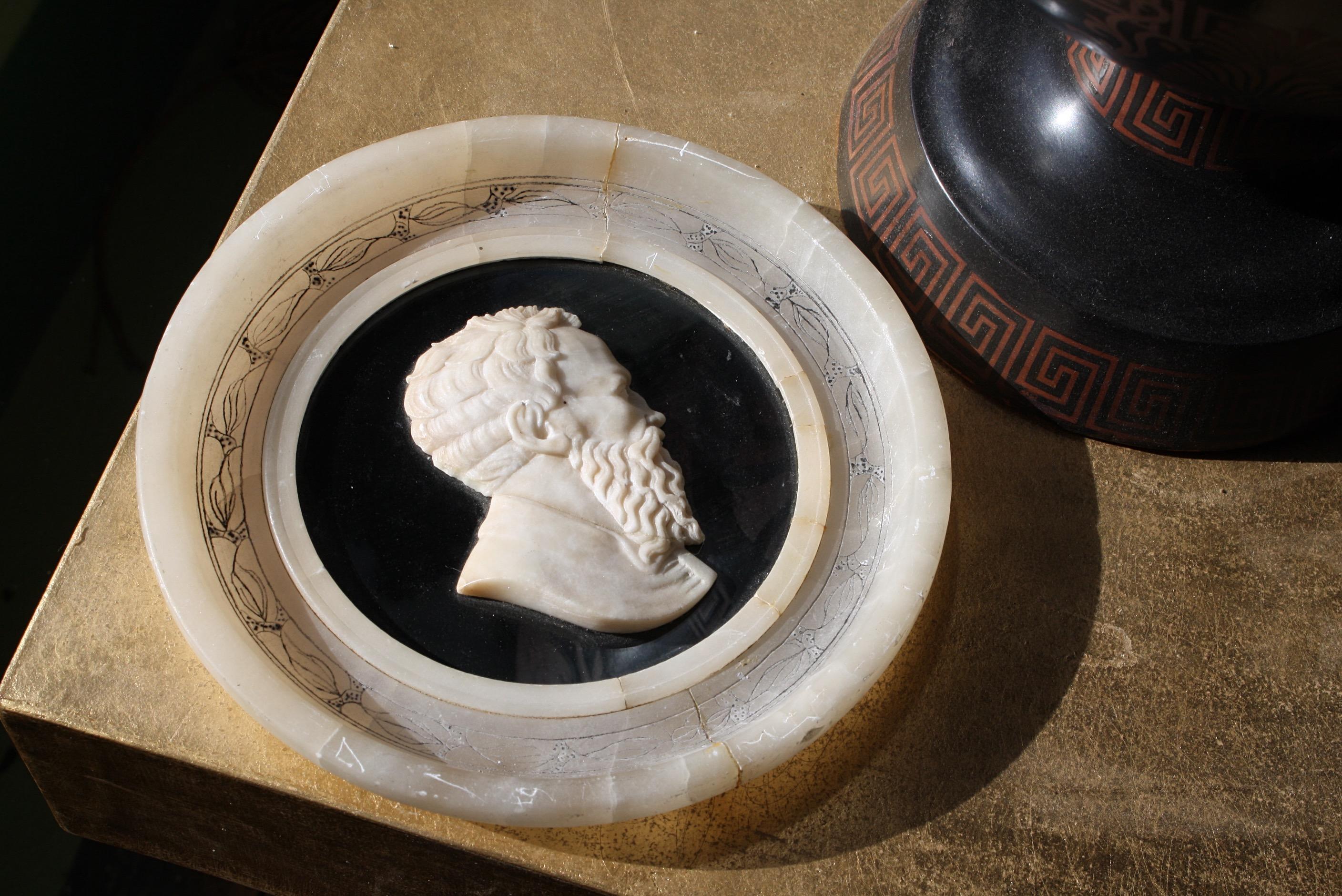 A fine profile portrait roundel of an elderly gent, mounted on a contrasting Ashford black marble ground on an alabaster roundel withs graffito and inked decoration.

19th century in age European in origins

Some elderly repairs are apparent,