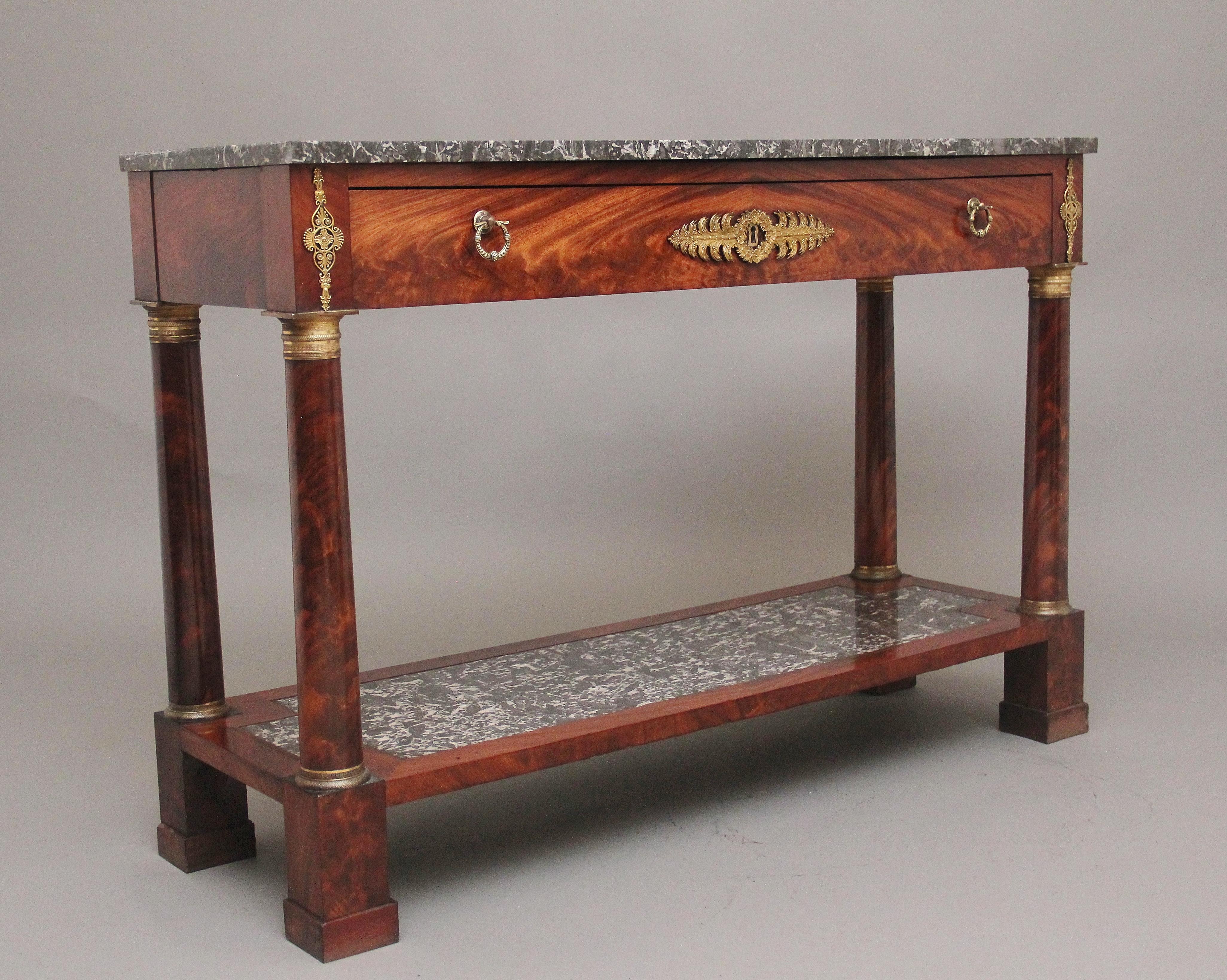 Une fabuleuse table console française du 19ème siècle en acajou avec dessus en marbre gris veiné d'origine au-dessus d'un seul tiroir en frise doublé de chêne, avec une belle façade de tiroir figurée et des poignées en laiton d'origine et des