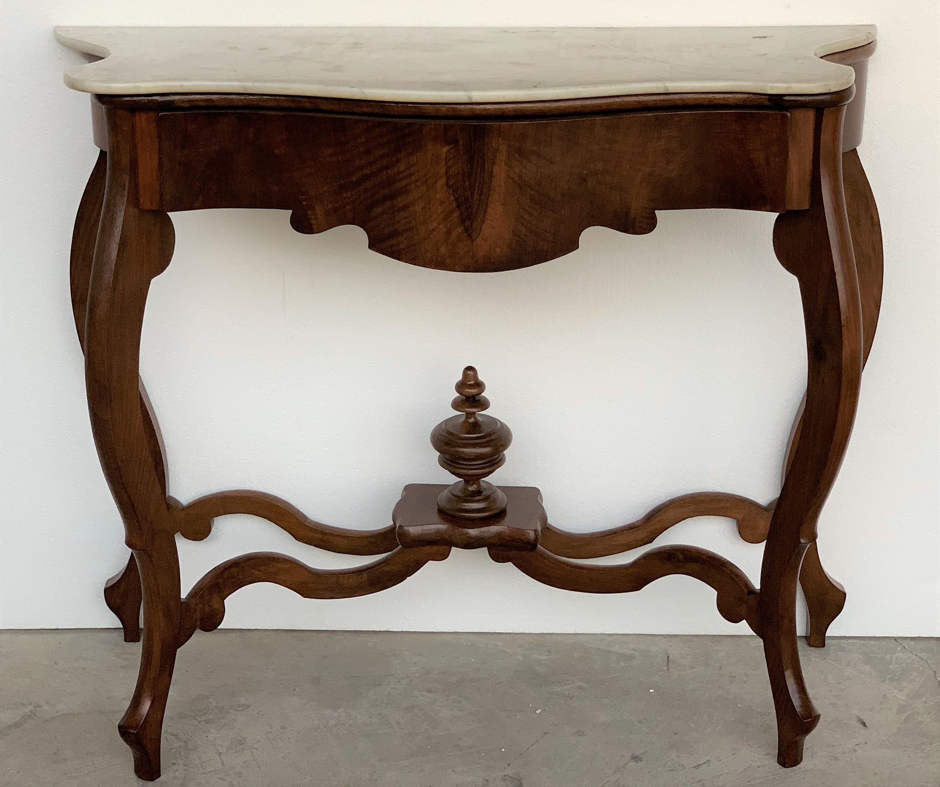Walnut console table with four curved legs united by an urn stretcher beneath a marble top.