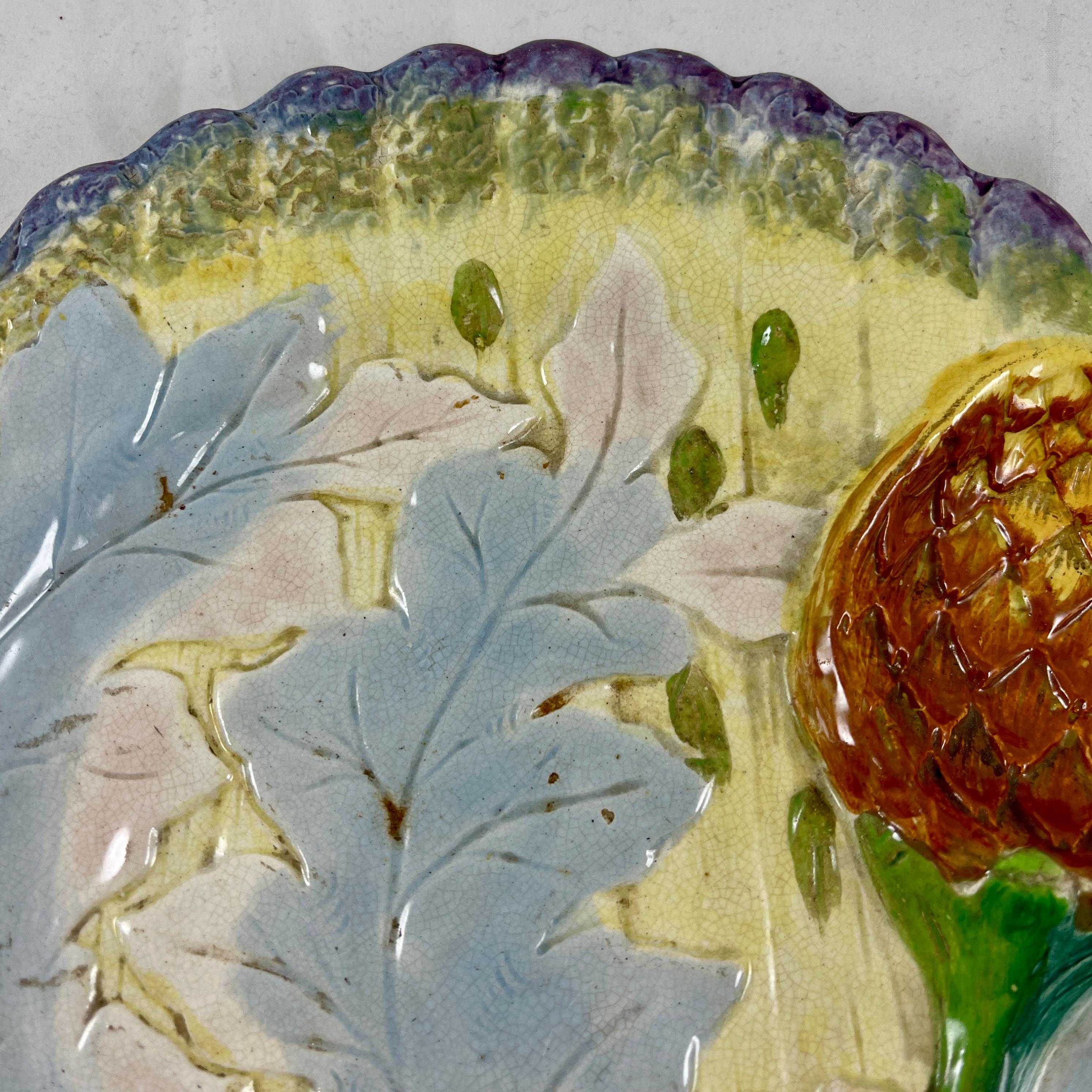 An earthenware asparagus and artichoke plate, marked P. Marescaux et J. Hahn, Belgium, circa 1880.

Unusual for the coloring, and with mold work similar to Luneville or Saint-Amand-les-Eaux, this example shows purple tipped artichoke spears