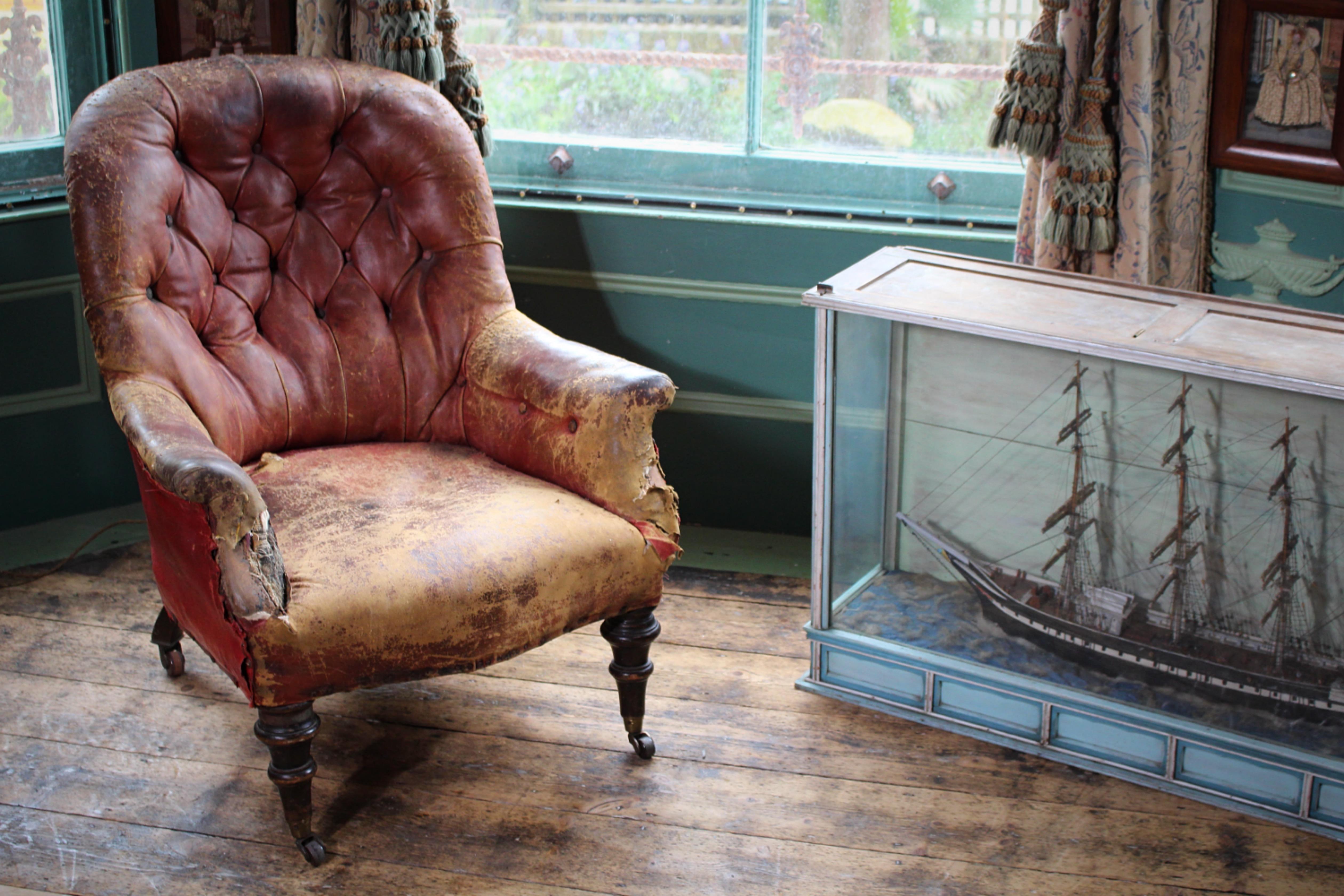 A mid victorian maroon leather tub chair, it's been well loved and has a wonderful look. Wear and tear, discolouration, stains and old repairs.



The leather is in perfectly good condition, supple and fit for purpose. Some losses around the arm