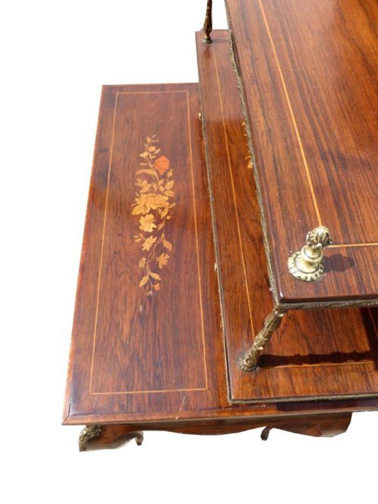 For sale is a good quality 19th Century Rosewood and Marquetry Inlaid Bonheur Du Jour. The piece has an inlaid up stand to the back, decorated with original ormolu mounts and edging, below this there are two drawers above one long drawer which opens