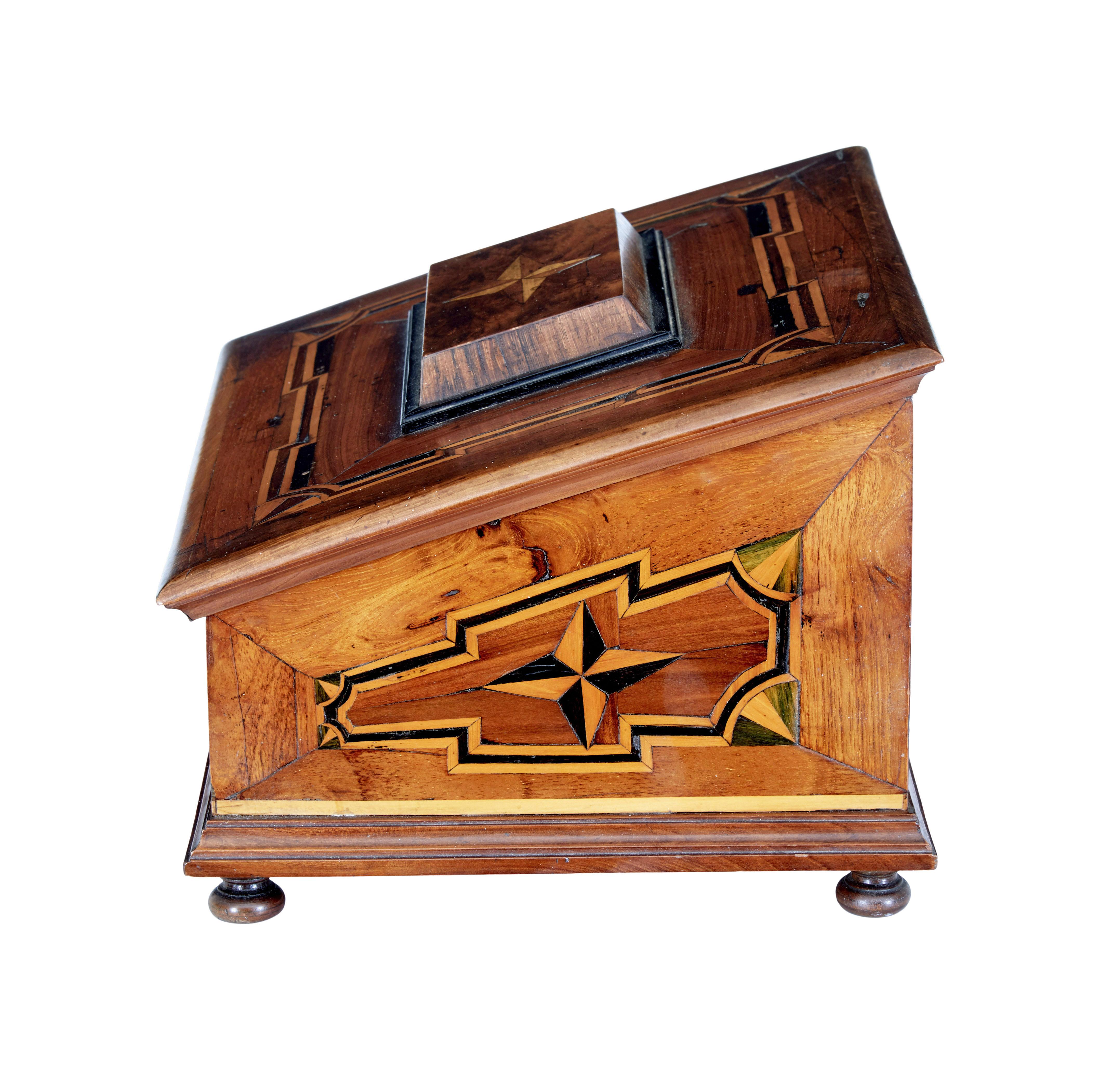 Scatola da tavolo in legno intarsiato del XIX secolo, circa 1890.

Scatola da tavolo di buona qualità rivestita di intarsio su tutte le superfici. Fronte inclinato con pannello decorativo a stella.  La parte superiore si apre per rivelare un interno