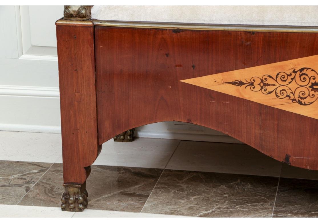An exceptionally well made 19th C. Aesthetic Movement period bench, likely European, the cresting rail with intricate marquetry with winged figures, trailing vines and acanthus leaf motifs. The S-form back post with foliate inlay and conjoined with