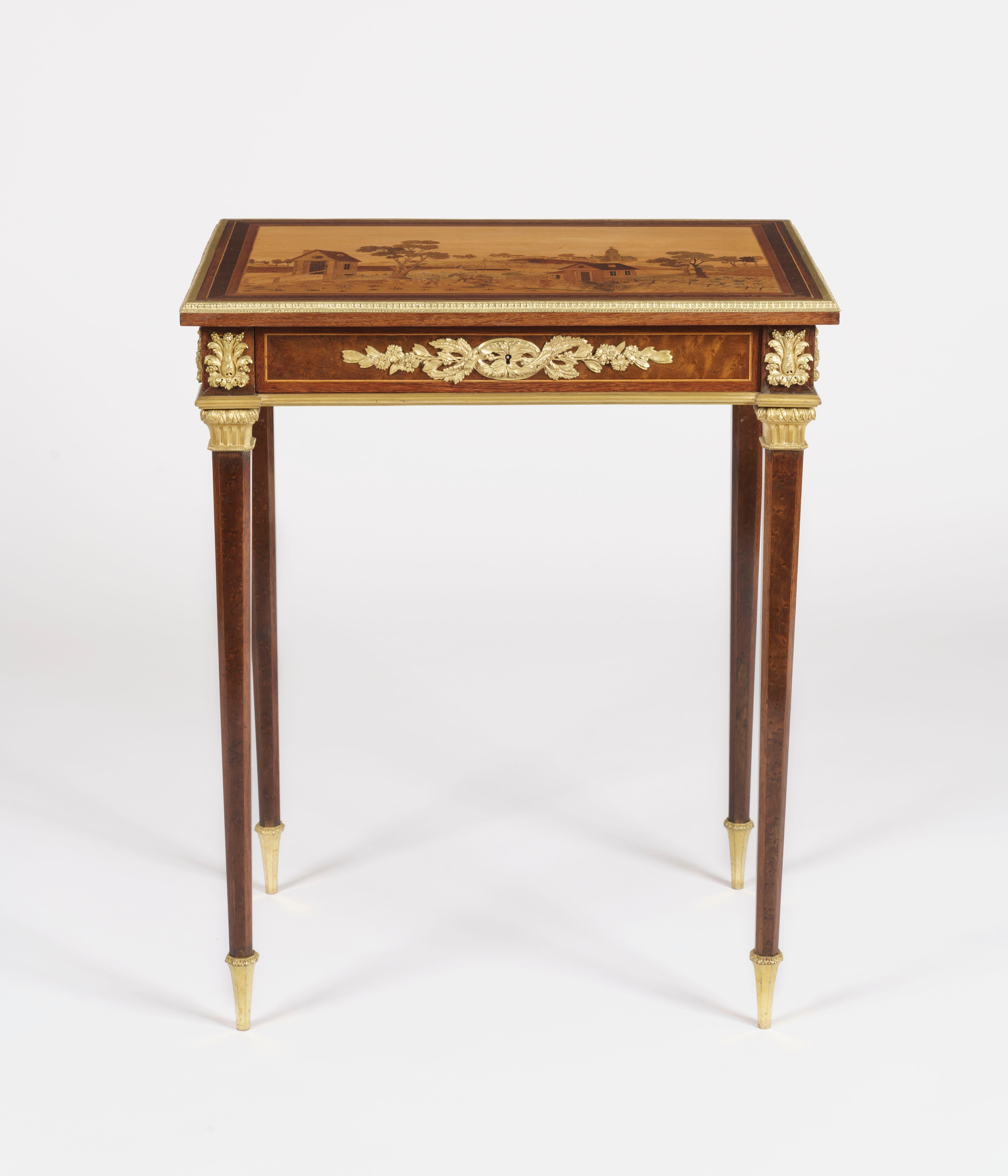 A fine quality side table
In the manner of Charles Topino

Of rectangular form, constructed in various specimen woods including thuya, walnut, boxwood, and yew, and having ormolu bronze adornments; rising from tapering octagonal legs and having