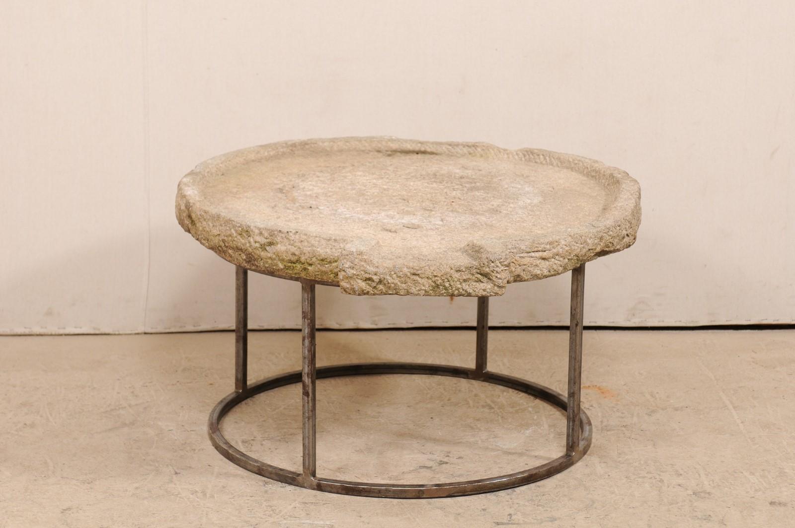 A 19th century Mediterranean stone trough table on custom base. This unique coffee table has been fashioned from a 19th century stone trough, once used in the production to press olives into oil. The round-shaped stone has been carved of hand and