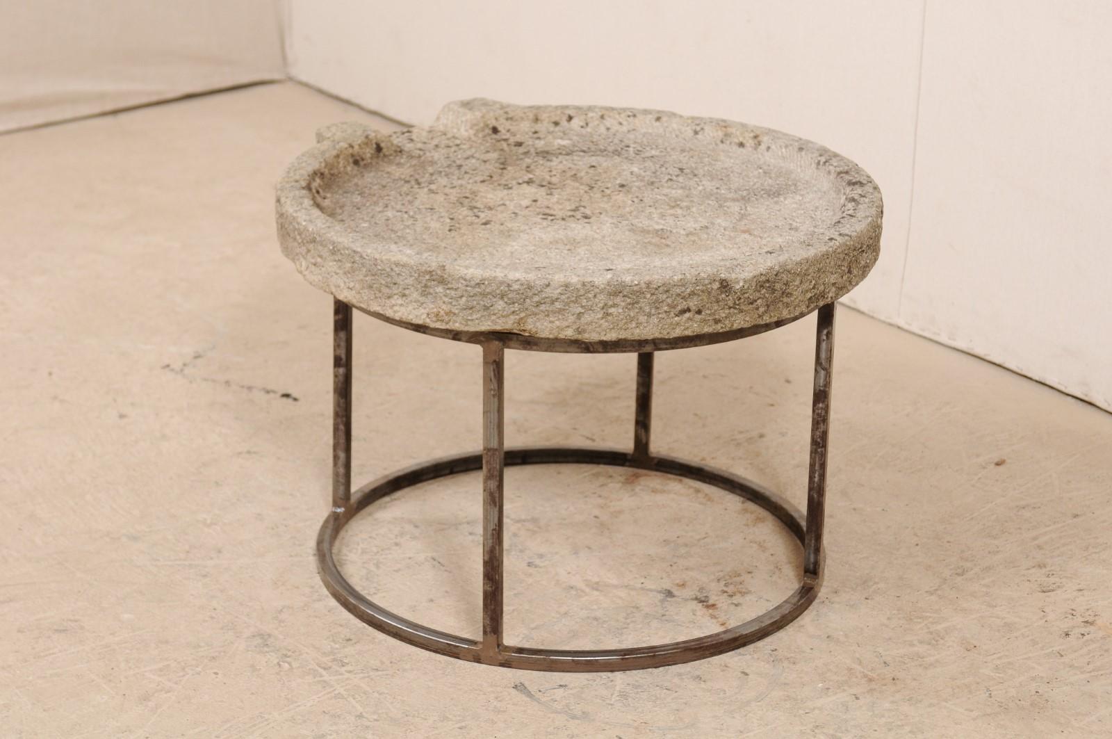 A 19th century Mediterranean stone trough table on custom base. This unique coffee table has been fashioned from a 19th century stone trough, once used in the production to press olives into oil. The round-shaped stone has been carved of hand and