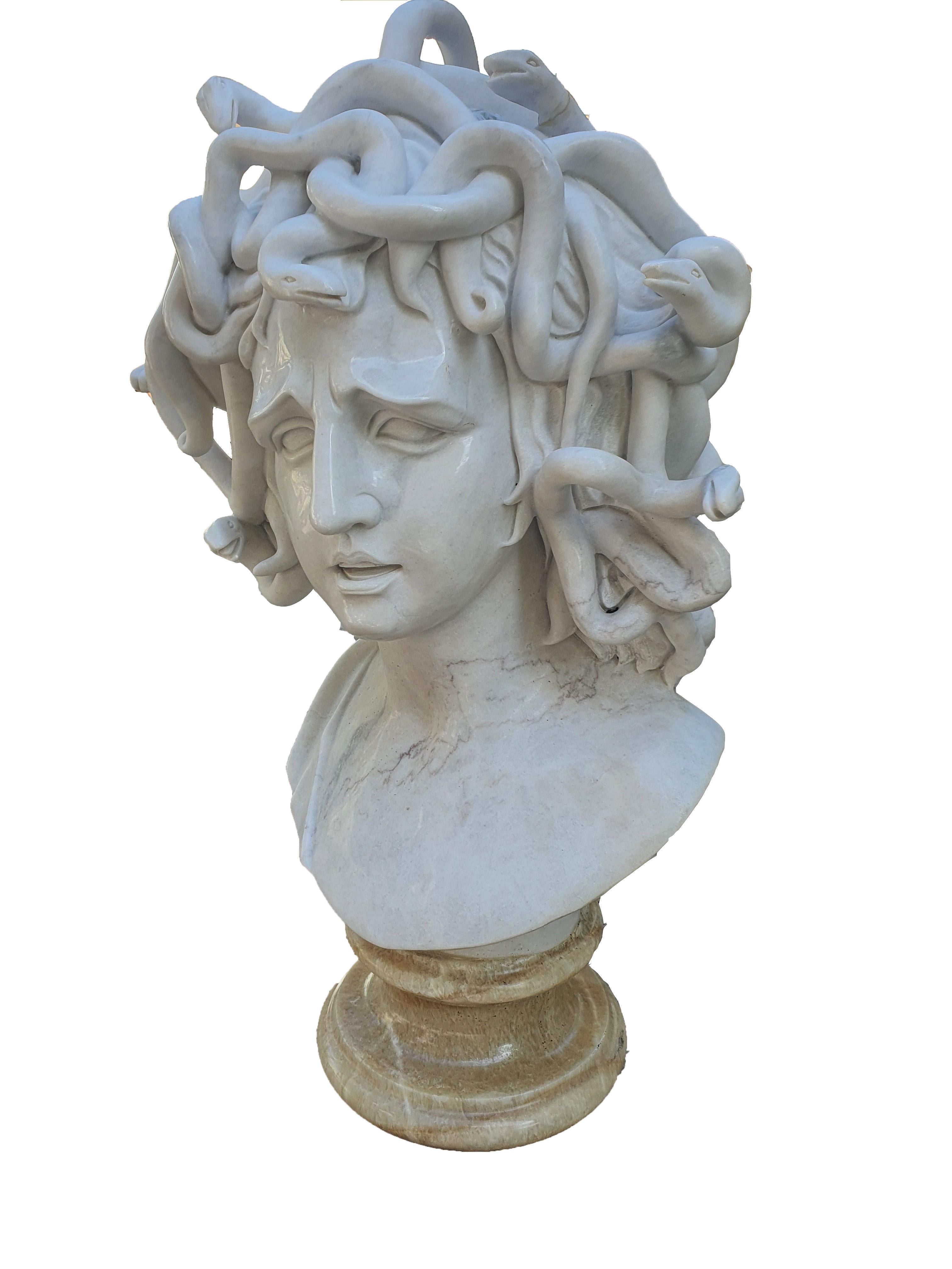 Bust in white statuary marble, depicting Medusa, a famous character from Greek mythology. The bust is made of finely sculpted white statuary marble, mounted on an onyx base.