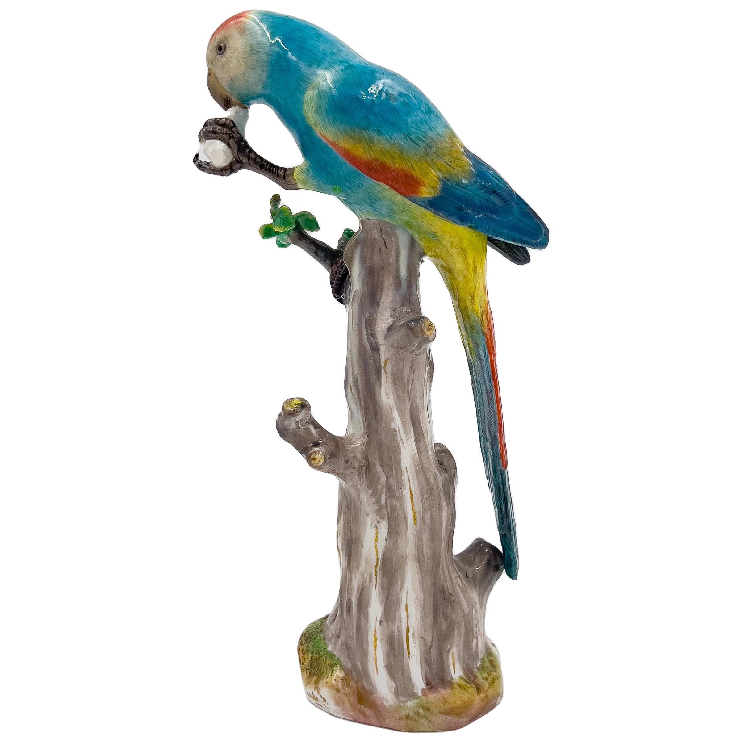 This exquisite Meissen animal figurine from the 19th century features a vibrant, multi-colored parrot perched on top of a tree stump while enjoying its meal. The craftsmanship is evident in the intricate details of the figurine, capturing the beauty