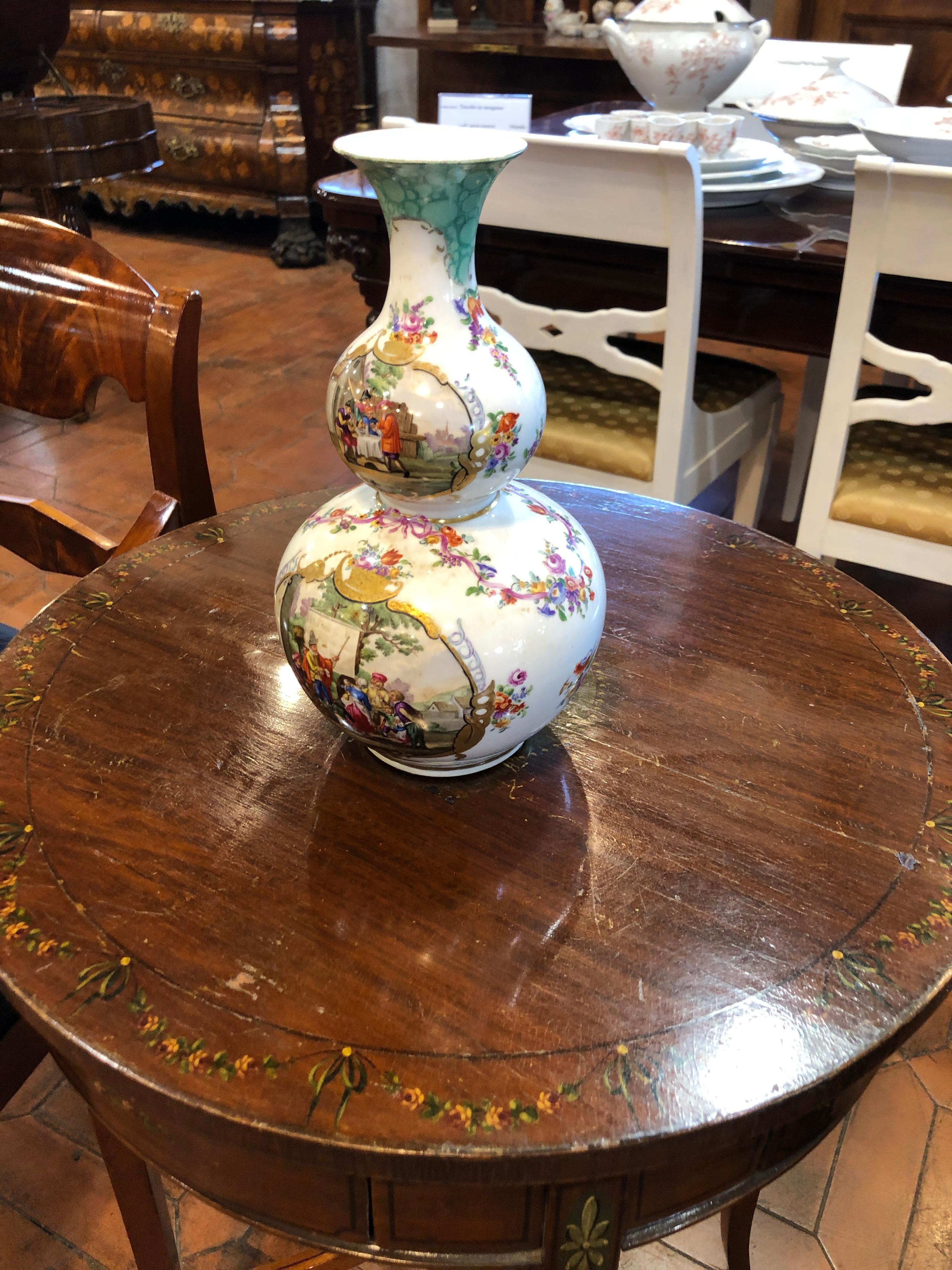 Beautiful German porcelain vase, stamped AR, Augustus Rex (Meissen), hand painted with scenes of daily life on one side, the other side is embellished with figures with floral motifs. The vase is in excellent condition and does not carry porcelain