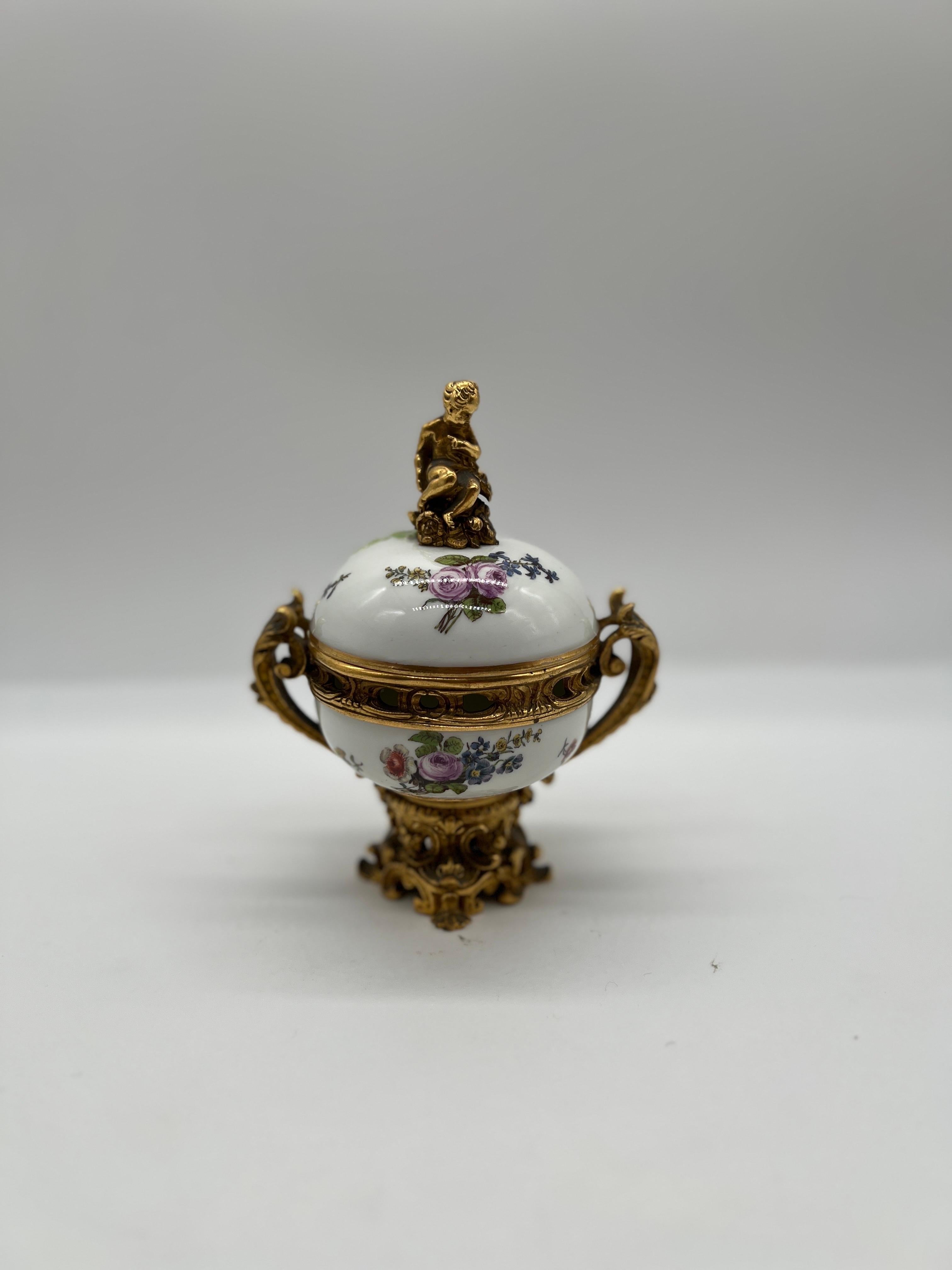 Meissen Porcelain (German, founded 1710), mid 19th century.

A beautiful and fine quality Meissen porcelain potpourri urn. The porcelain which is decorated polychrome decorated floral motifs and a raised green vine which accents the bronze cherub or