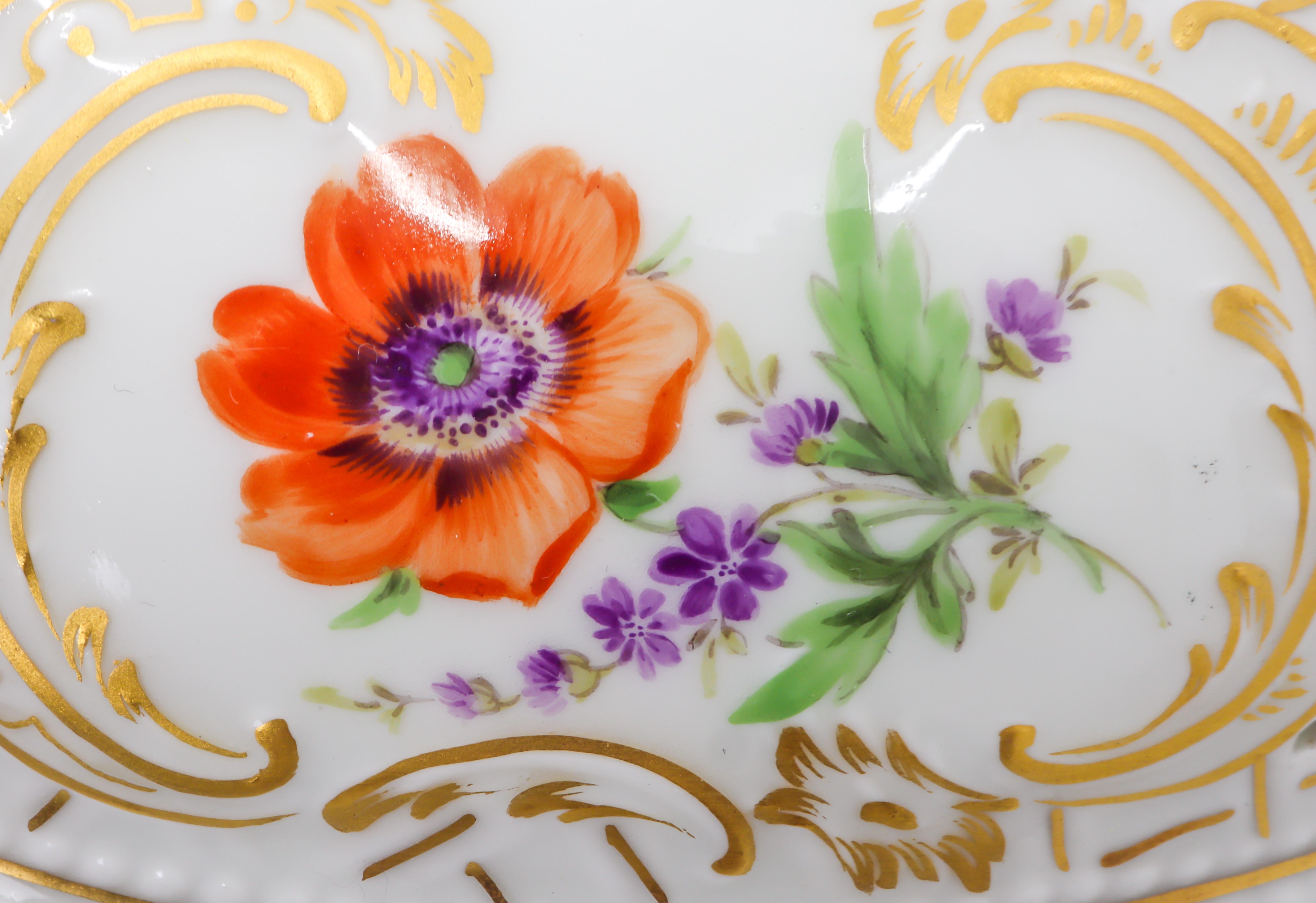 German hand painted porcelain bowl with flowers, the lid of the bowl has a strawberry finial, finely painted with flowers enclosed in cartouches on both lid and plate with open work, gilded pattern throughout. Opening for spoon insert on the lid