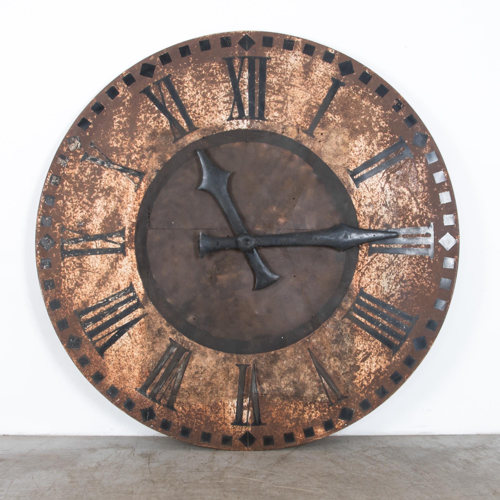 Reclaimed from an aging clock tower, these large scale clock faces were manufactured in France in the late 19th century. Aged after over a century facing the elements, the metal has a beautiful distressed patina with traces of a hand painted black
