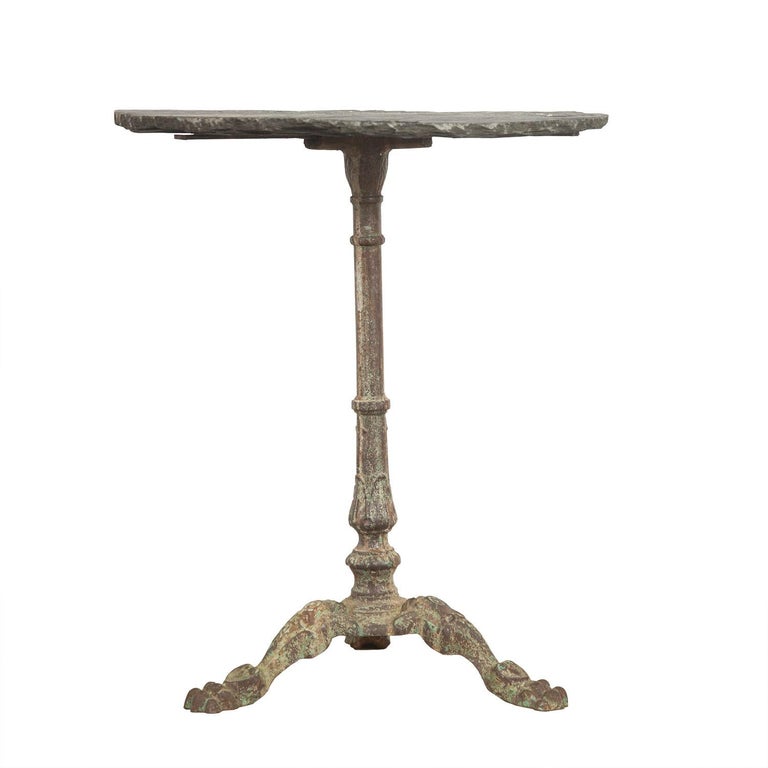 19th century cast iron table base with decorative lions paw feet, with later slate top. This piece has a super patina.