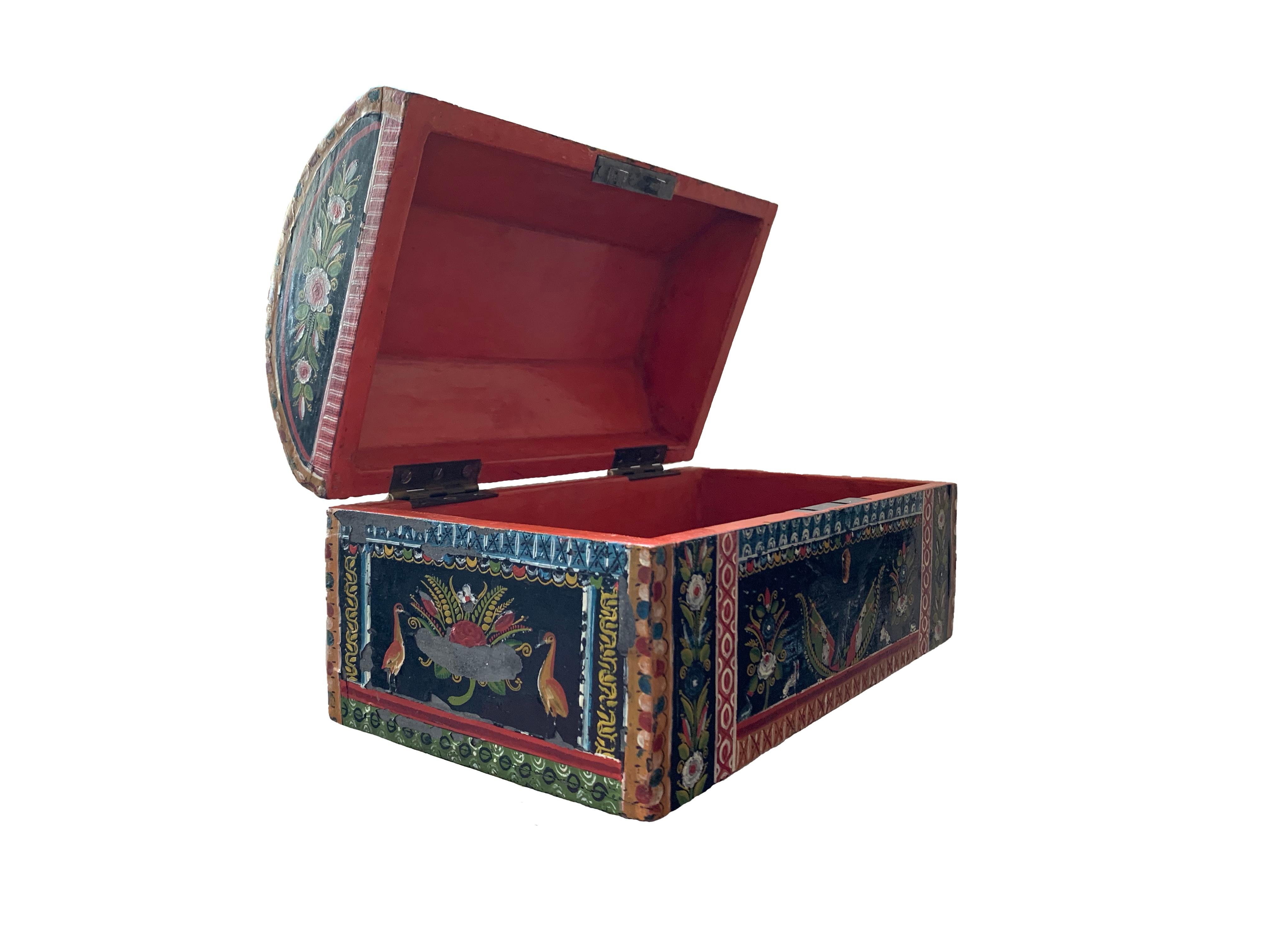 This chest from the 19th century is a majestic example of the technique known as ‘maque’, or lacquer, developed in Mexico over the centuries. It is lacquered in an orange background and profusely decorated on all sides. On its front a the ornament