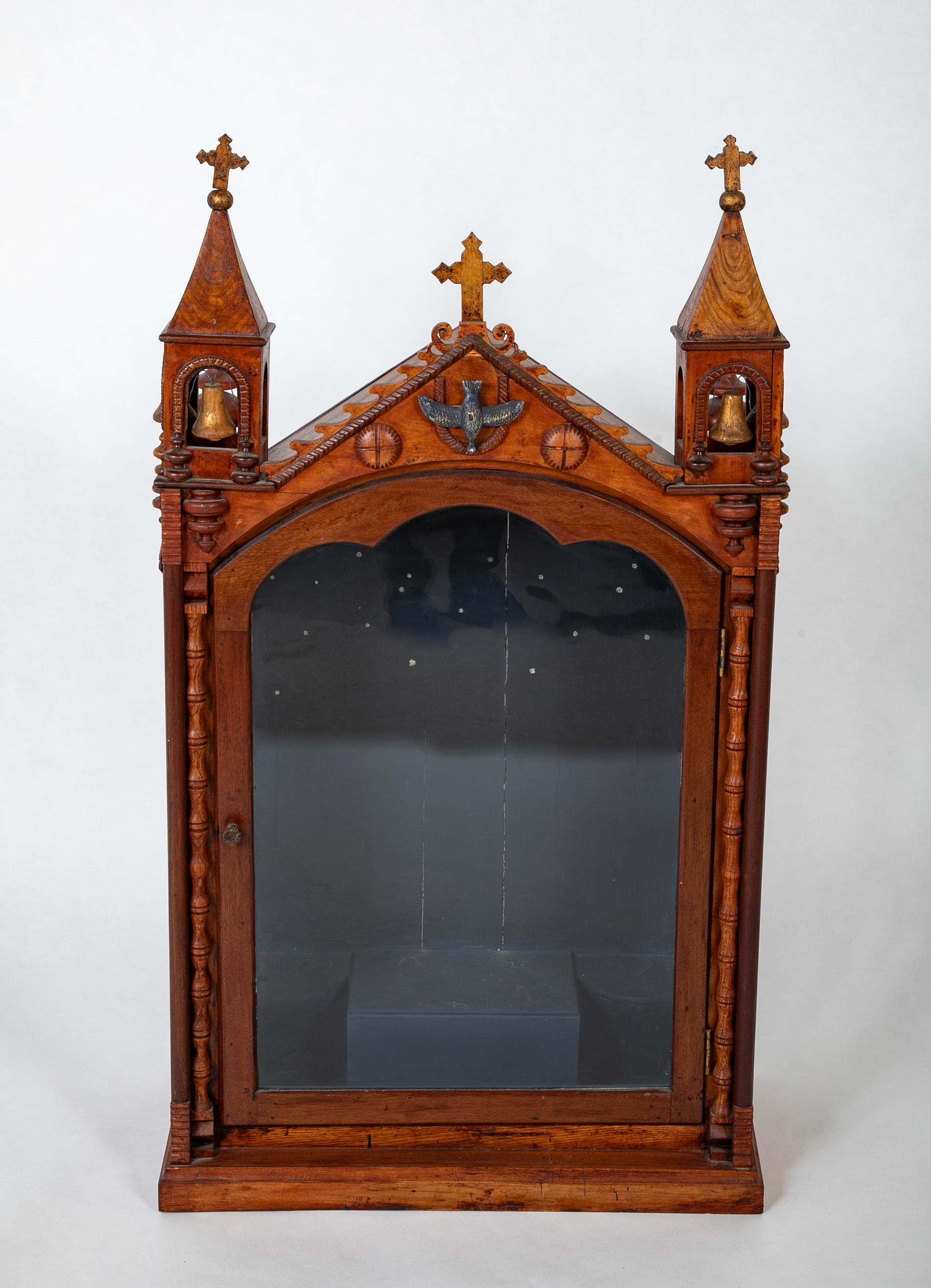 19th century Spanish Colonial shrine for a Santos or statue of the Virgin Mary in the form of a church likely from New Mexico. Topped with three crosses with traces of gilding, two cupolas housing two gilt wood bells each, a silver gilt dove in