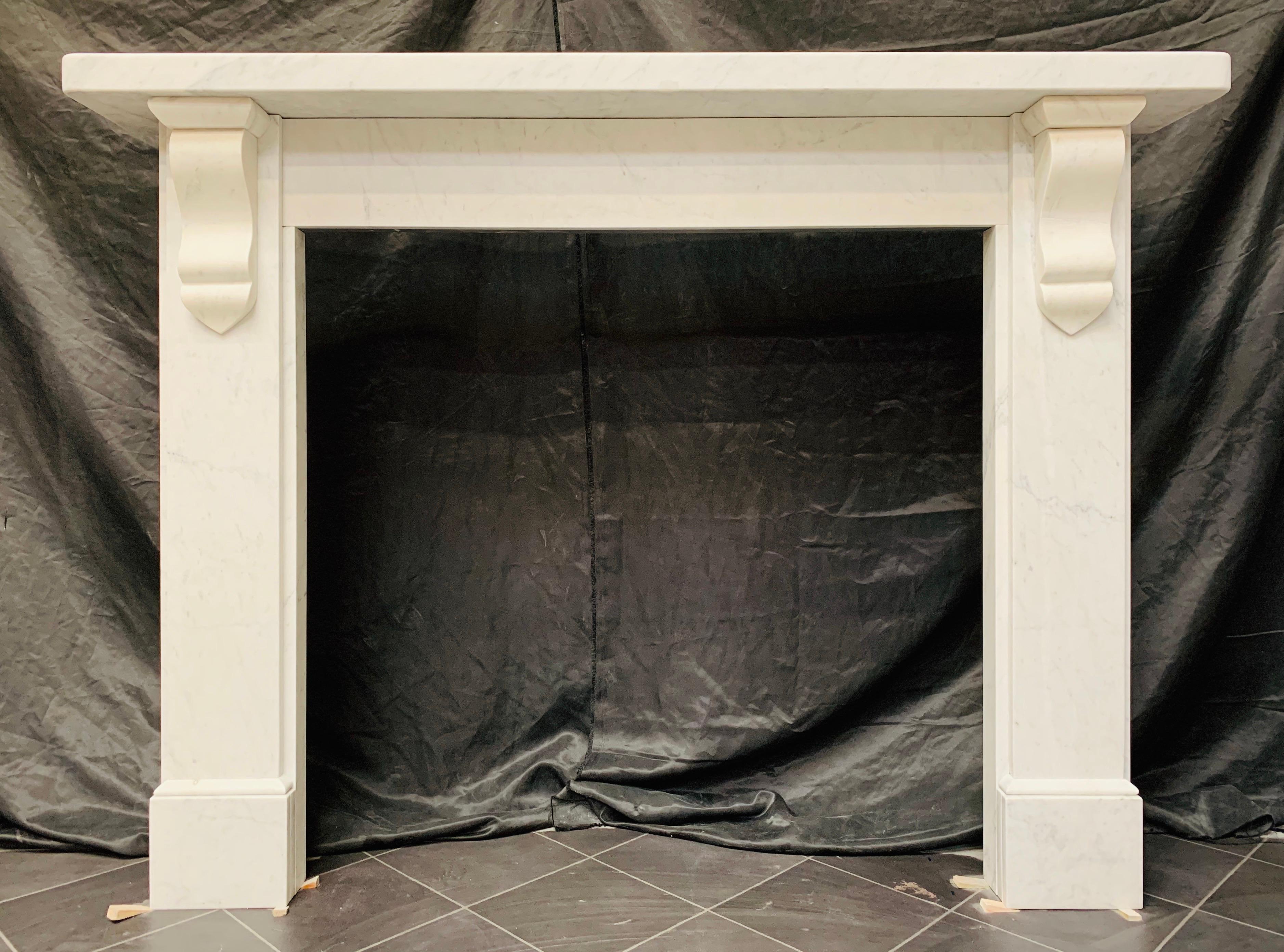 A simple and versatile 19th century Mid Victorian lightly veined Carrara marble fireplace surround with geometric corbels. A substantial square edged shelf sits above an unadorned frieze flanked by stepped jambs each with a geometric corbal and