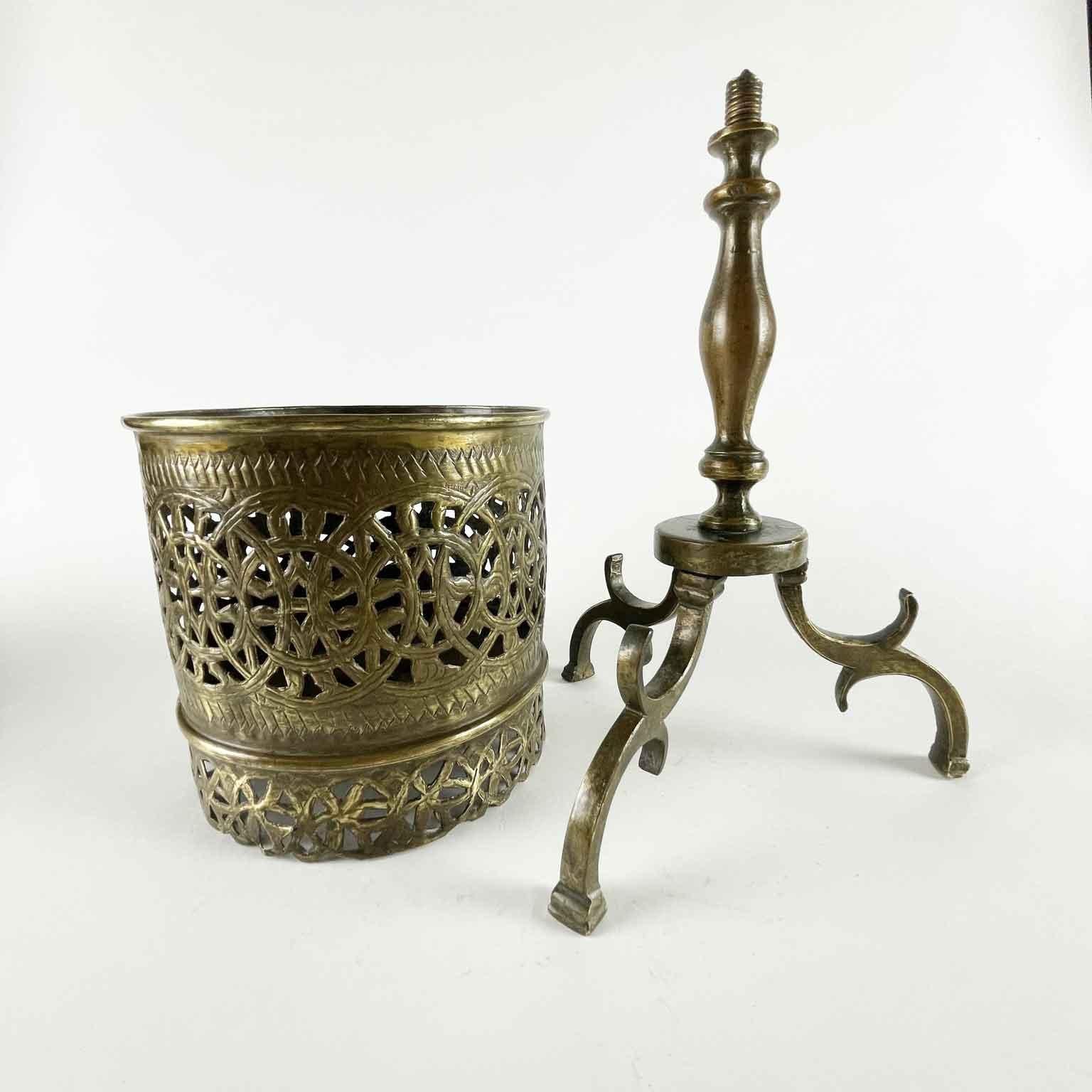 19th century Middle Eastern Brass Brazier standing on tripod base featuring a central turned brass shaft, three cast brass feet at the base, a threaded pin joins the cylindric brazier container made of pierced and embossed sheet metal. Inside there