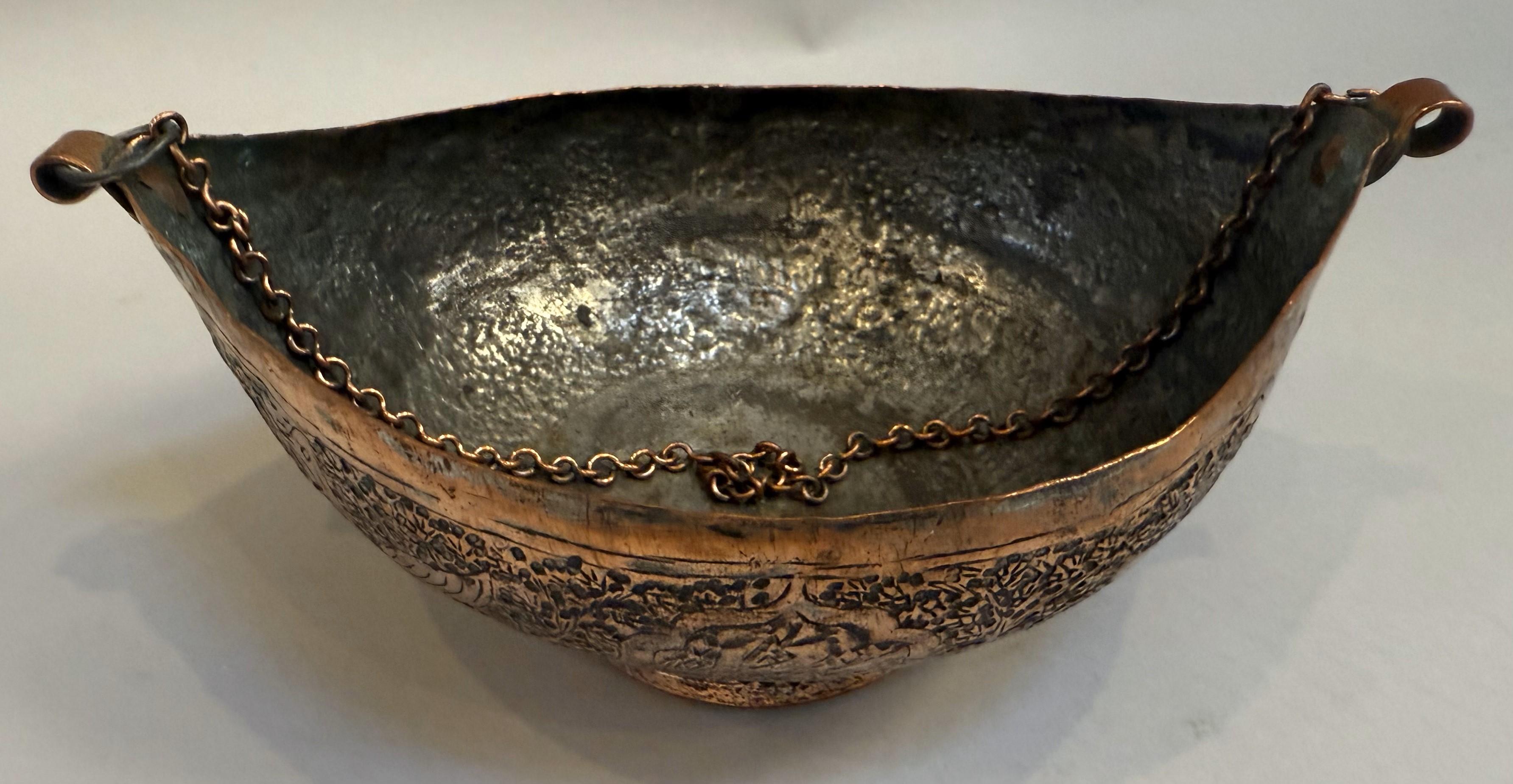 19th Century Middle Eastern Copper and Silver Vessel with copper chain handle. Richly decorated with hand-hammered peacocks and Arabic lettering.

A captivating 19th-century Middle Eastern copper and silver vessel, richly decorated and crafted circa