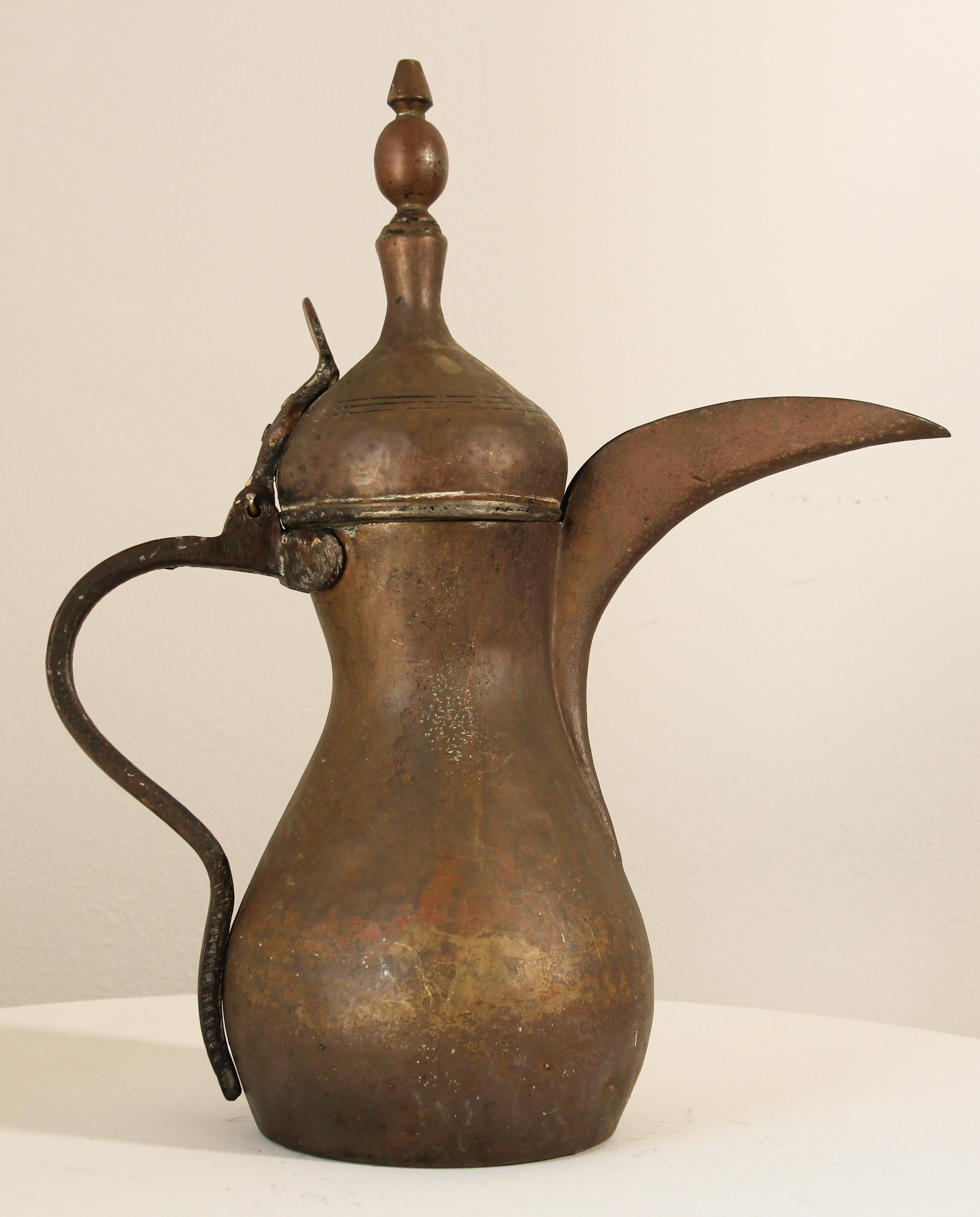 19th century Middle Eastern traditional Arabian tinned copper and brass Dallah coffee pot. 
Coffee pot hand-hammered and chased copper with riveted brass finish and a very large spout. 
Size: 16