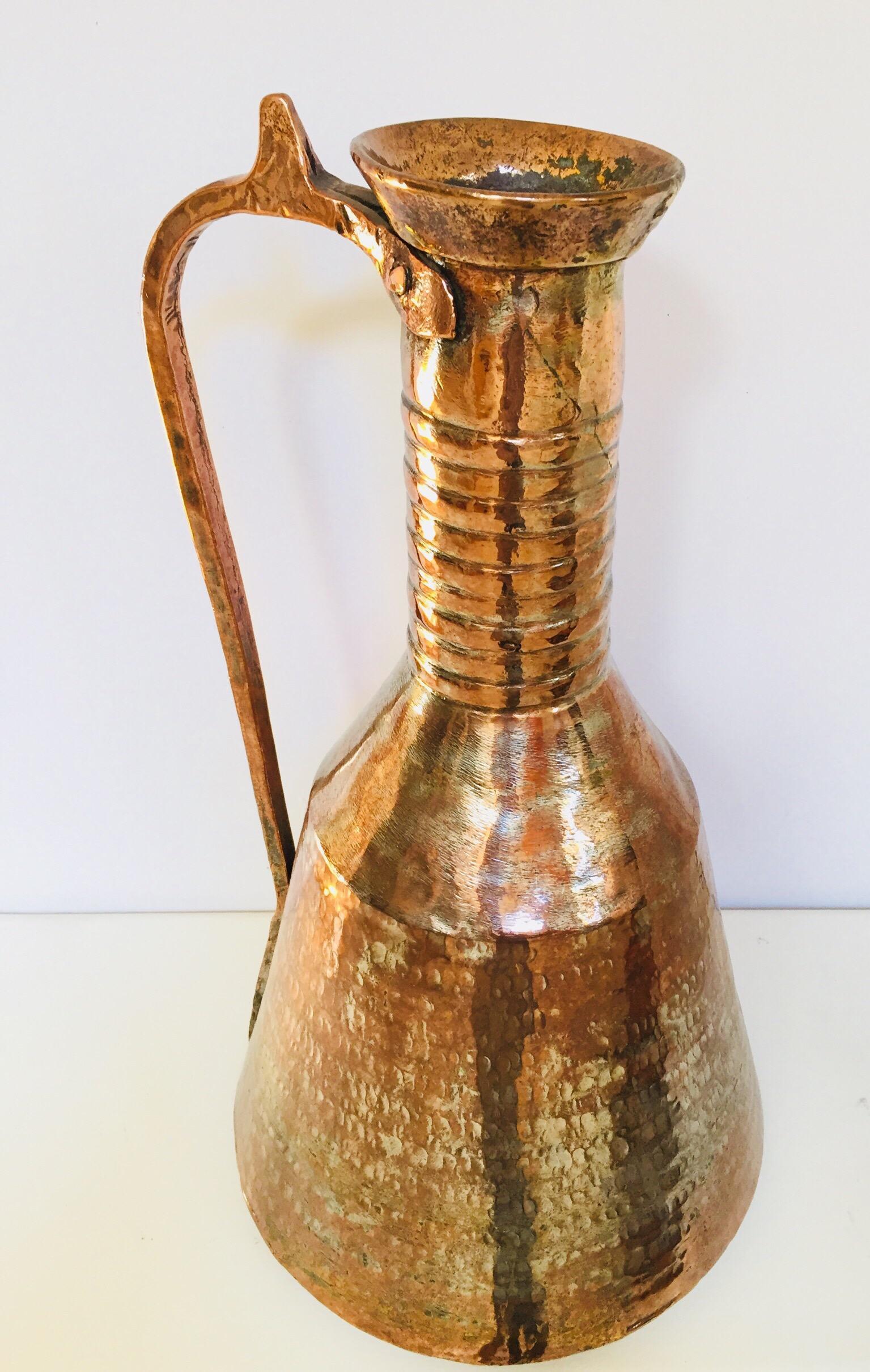 19th century Middle Eastern Persian tinned copper water jar with handle.
Moorish Arabic water ewer, hand tooled, hand-hammered heavy metal tinned copper vessel with brass handle.
Middle Eastern Asian traditional water vessel with riveted brass