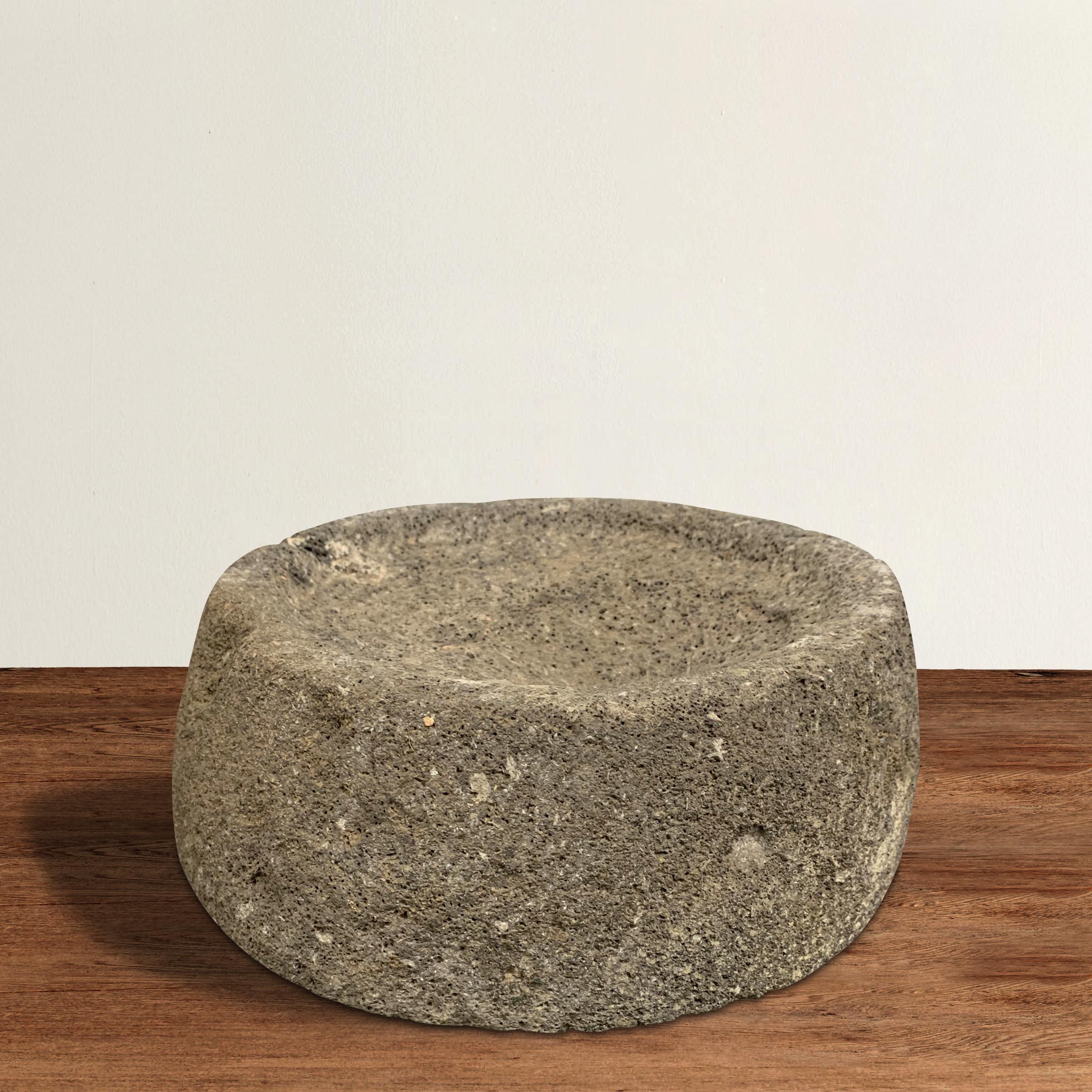 A wonderfully chic and primitive 19th century carved stone millstone with a convex surface that makes it perfect for use as a bowl in your kitchen, or as a catchall for your keys on a table in your entry.