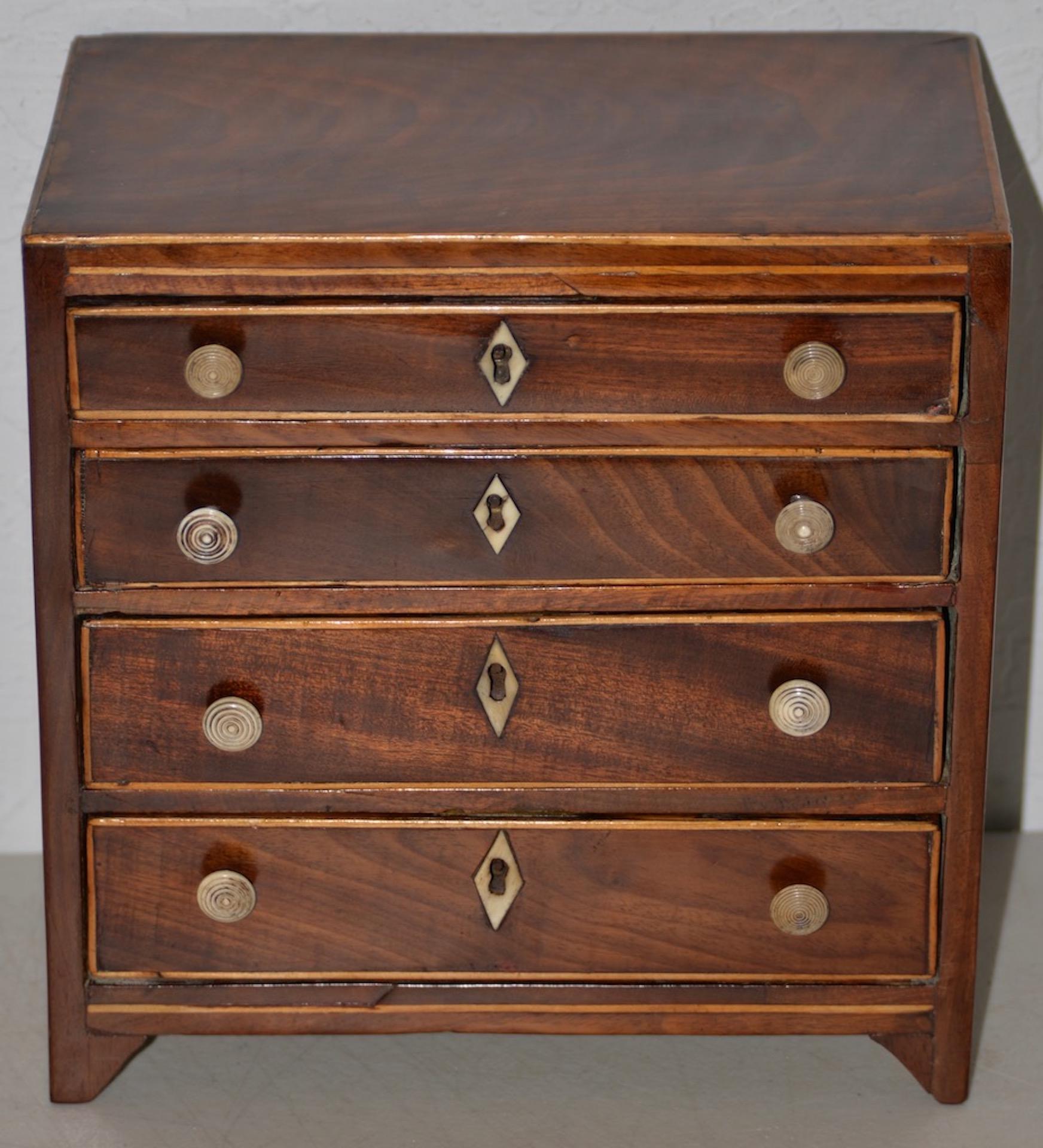 19th century miniature mahogany Salesman Sample chest of drawers with inlay

Beautiful salesman sample chest of drawers from stunning flame mahogany drawer fronts and inlay. 

The four drawer chest has inlay at the key holes, and one key fits