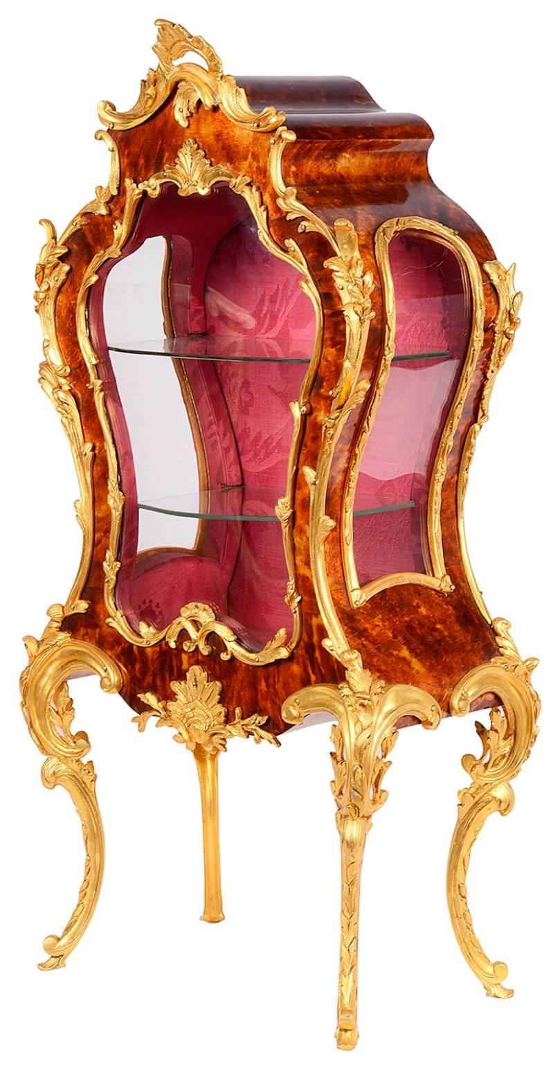 Eine hochwertige Miniatur-Tischvitrine im Rokoko-Stil des späten 19. Jahrhunderts im Louis-XVI-Stil mit vergoldetem Ormolu und Schildpatt. Er hat eine Bombenform und steht auf eleganten Cabriole-Beinen. Die Rückwand lässt sich aufklappen und gibt