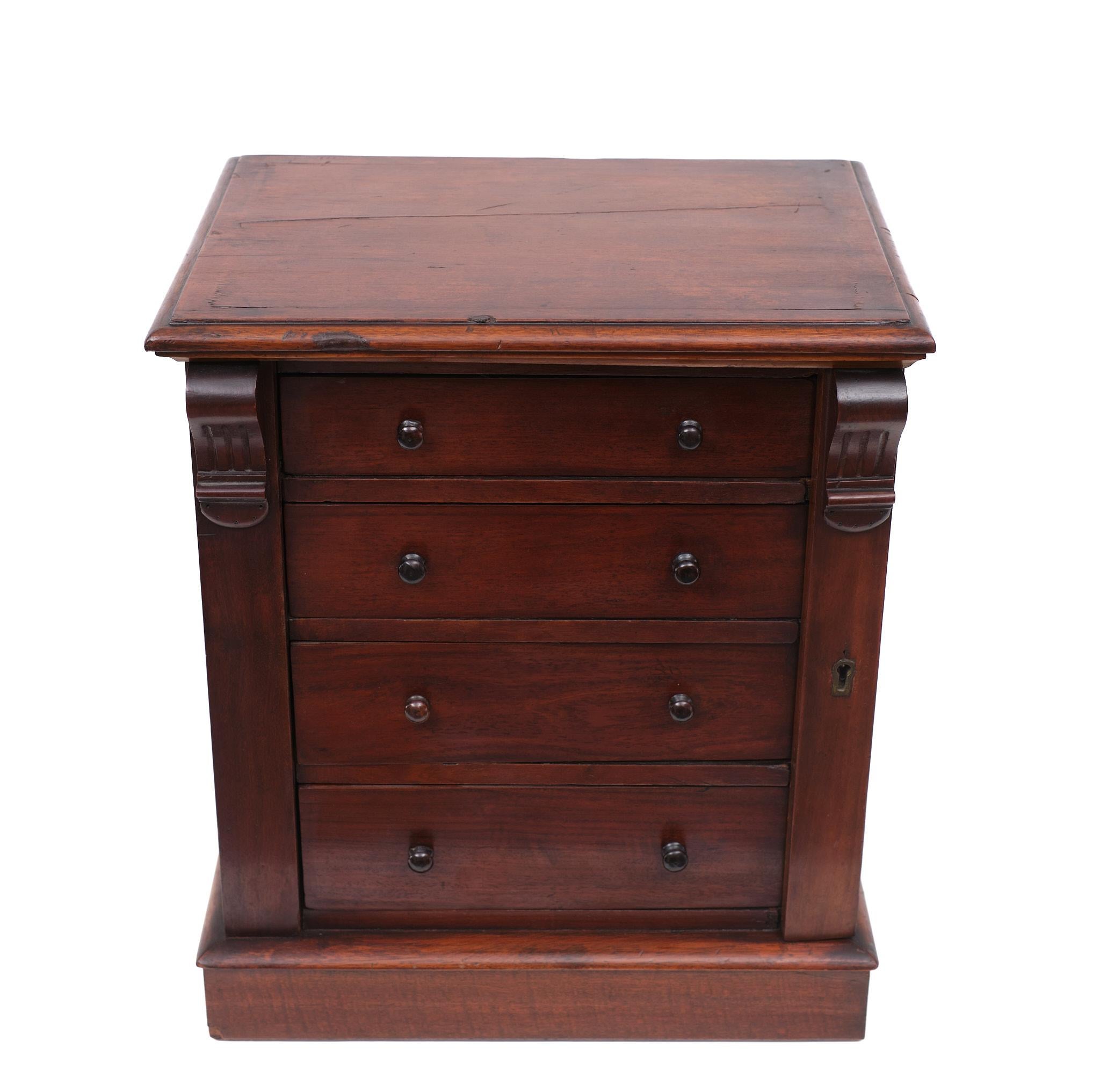 Beautiful miniature Wellington chest of drawers. Warm Mahogany color. 
All four drawers are locked by the hinged side pilaster on the right, terminating on a plain plinth base. Original key. Very nice Brass hardware.