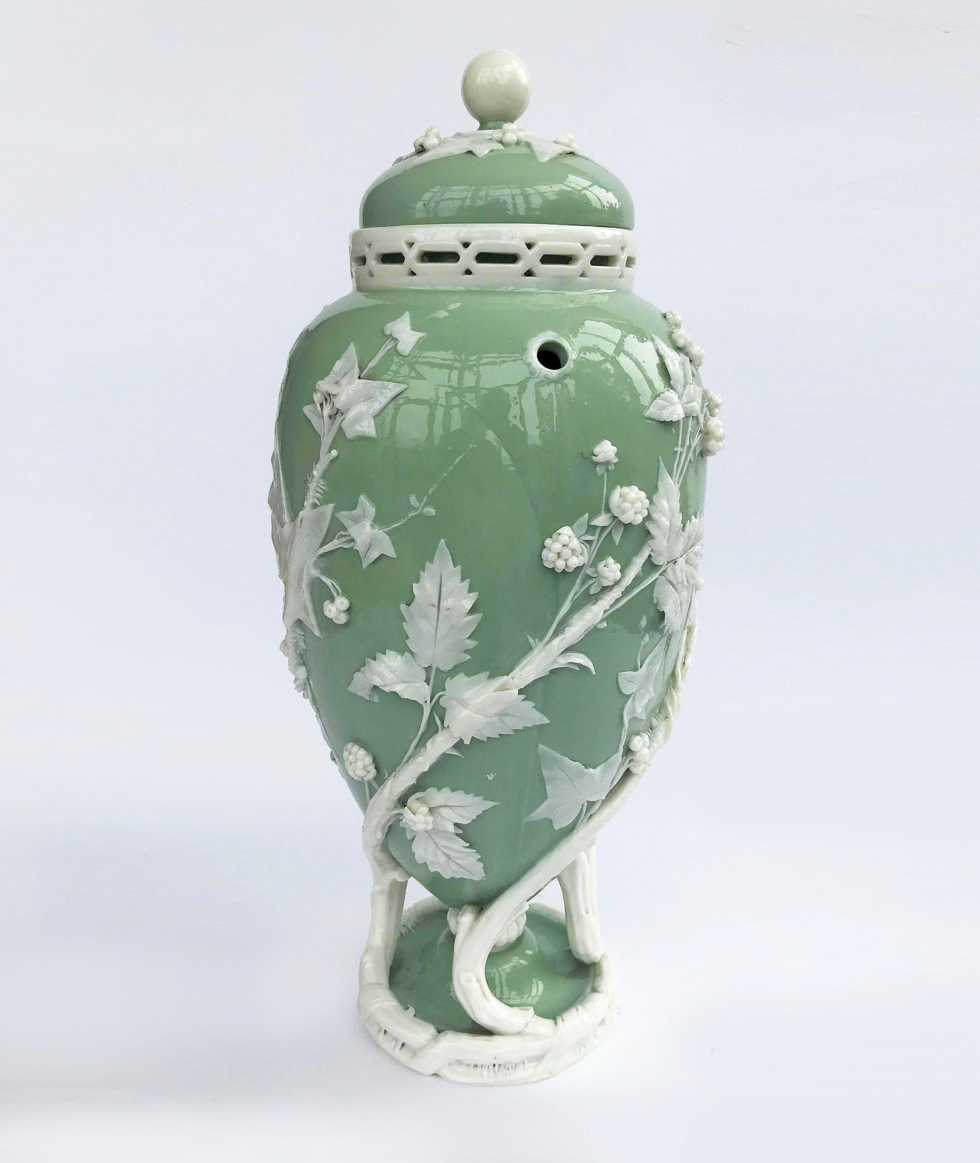 An very rare museum quality Minton Celadon Potpourri, circa 1868.
The celadon body decorated in pate sur pate blackberries, ivy, leaves and branches, the collar pierced, the cover with leaves and a ball knop, all supported on three spiralling