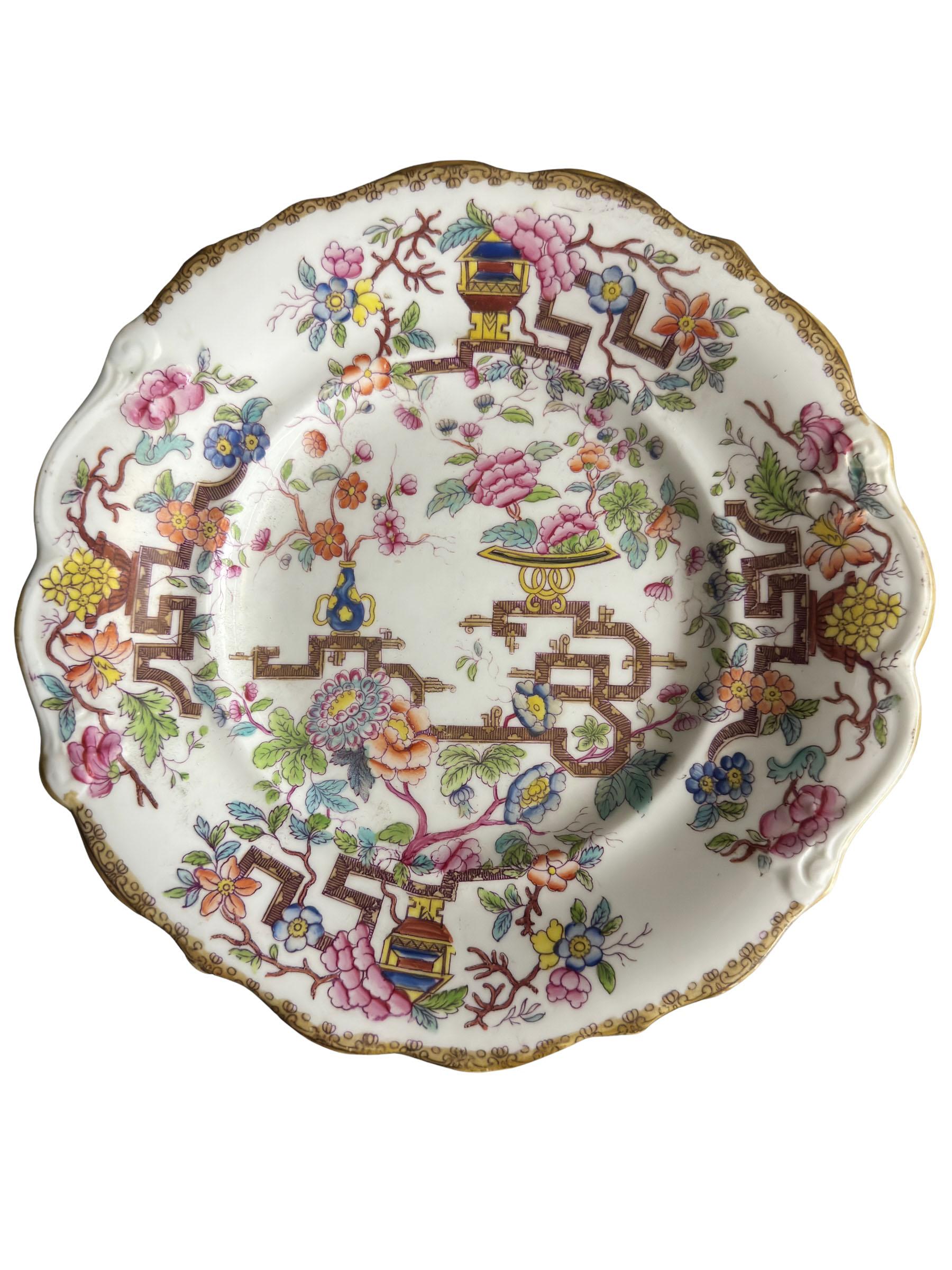 Assiette ancienne de chinoiserie Minton à bord festonné et doré. Arbre chinois avec des vases de pivoines et de fleurs peints à la main. Circa 1870s, Angleterre. Non signée.
