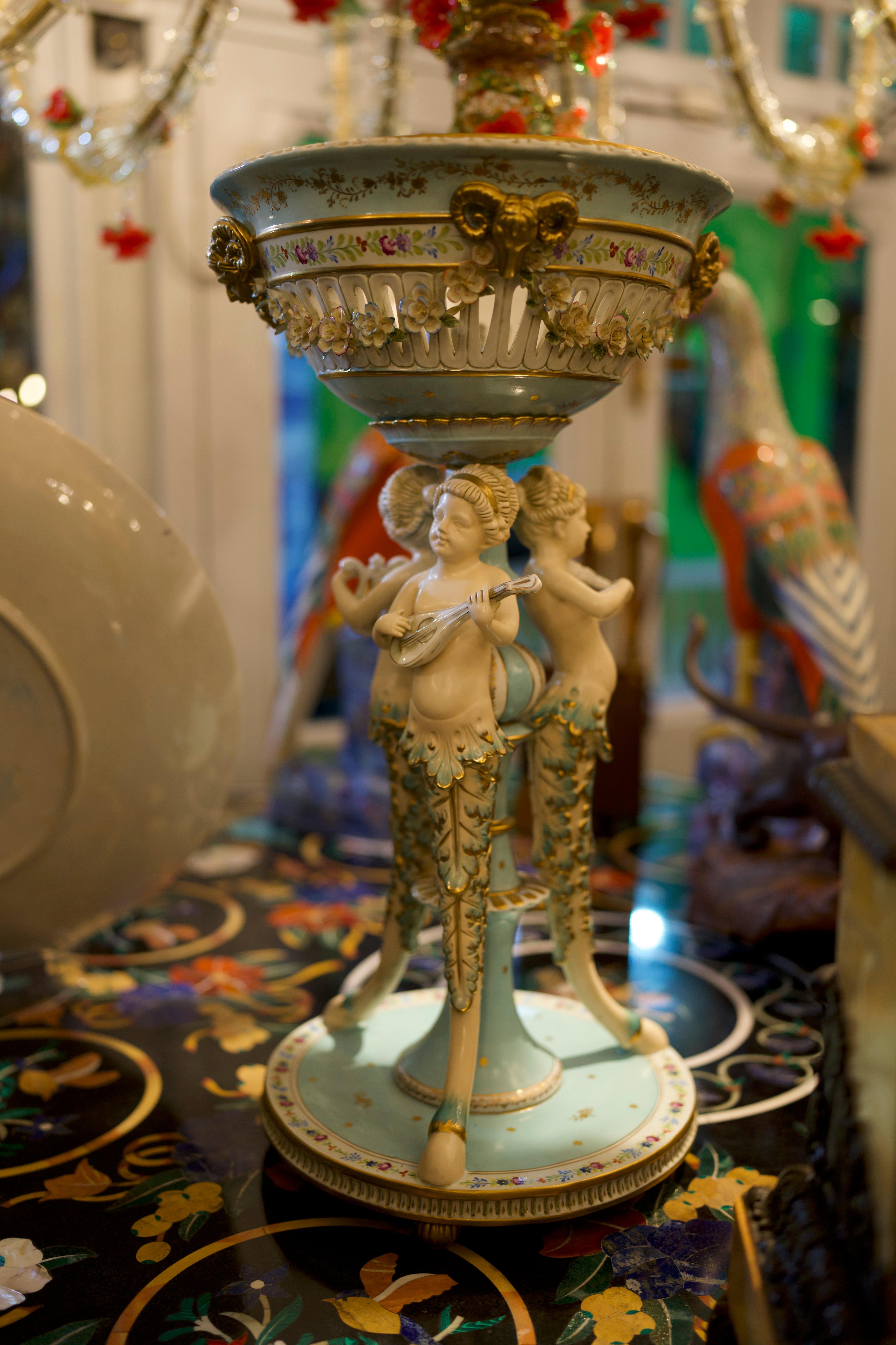A beautiful 19th century Minton Majolica figural pedestal planter.

A Minton England majolica jardiniere featuring three faun footed cherubian figures serving as pillars supporting a reticulated planter top. Each winged cherub connected with a