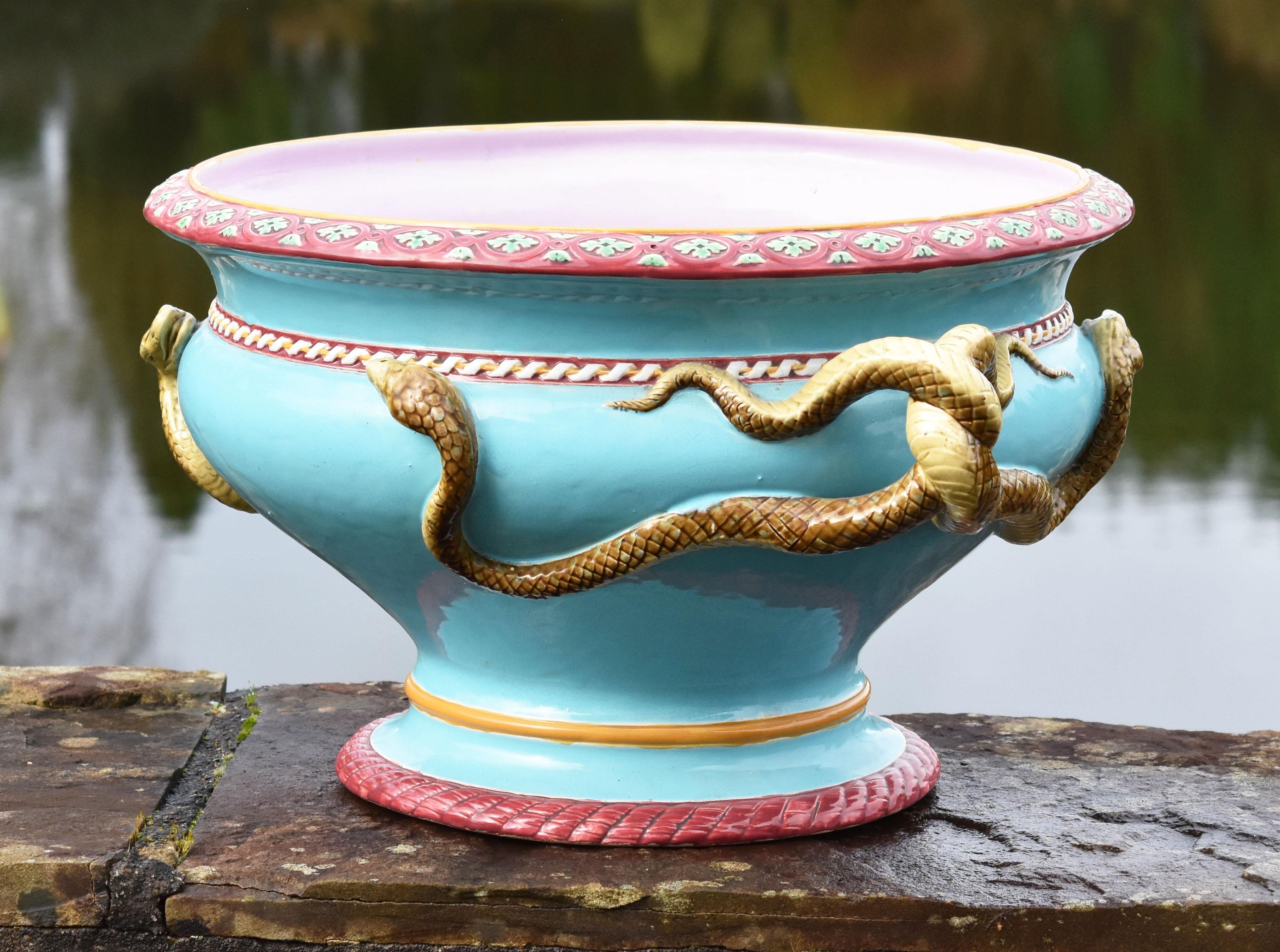 An excellent quality and condition, rare large size, Minton Majolica neoclassical designed snake handled jardinière circa 1876 Designed by the celebrated Architect Gottfried Semper.
The body flanked by entwined serpent handles beneath a spiral
