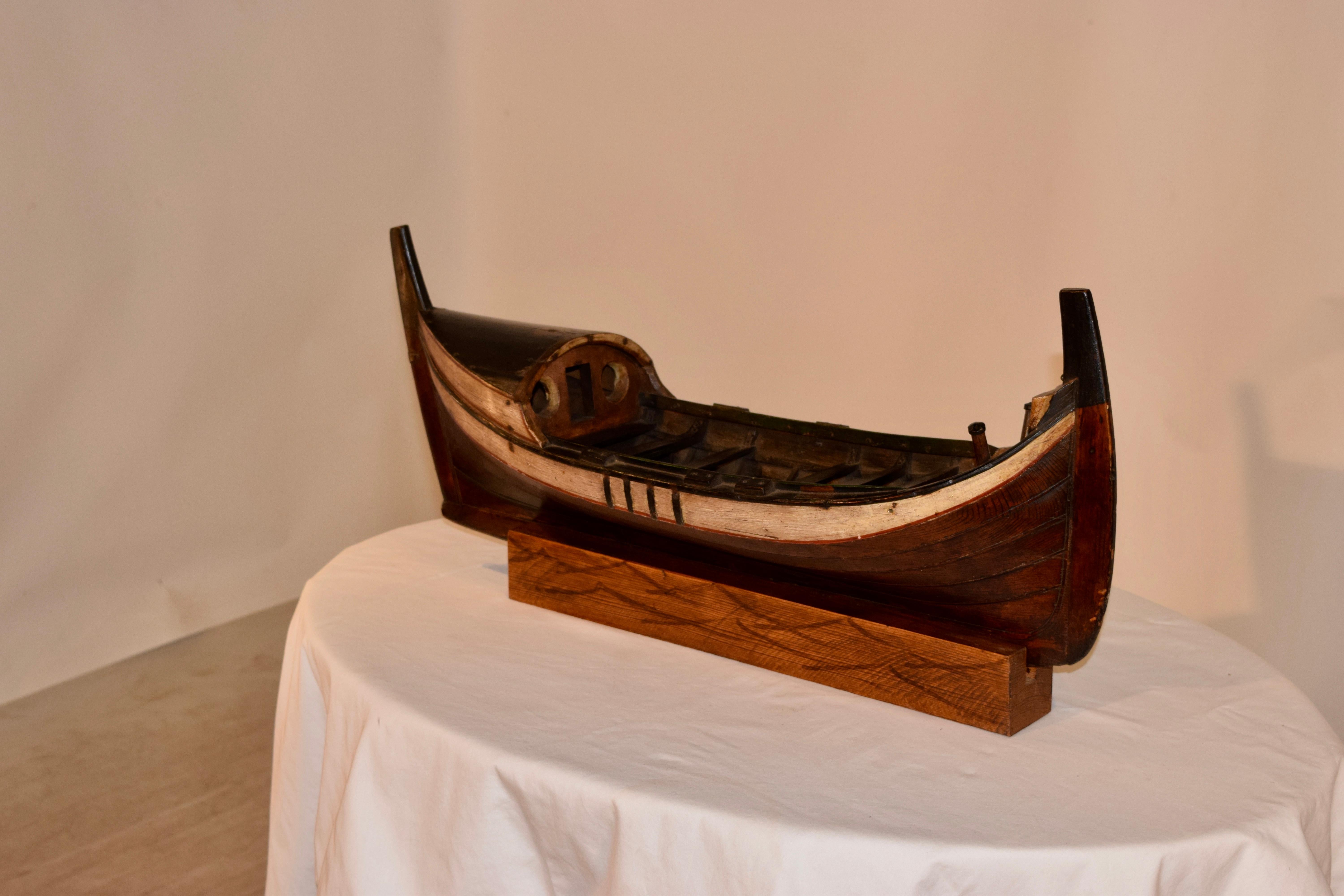19th century rustic model of a boat on a handmade stand, which is removable. The boat is hand painted and the stand has hand painted waves on it.