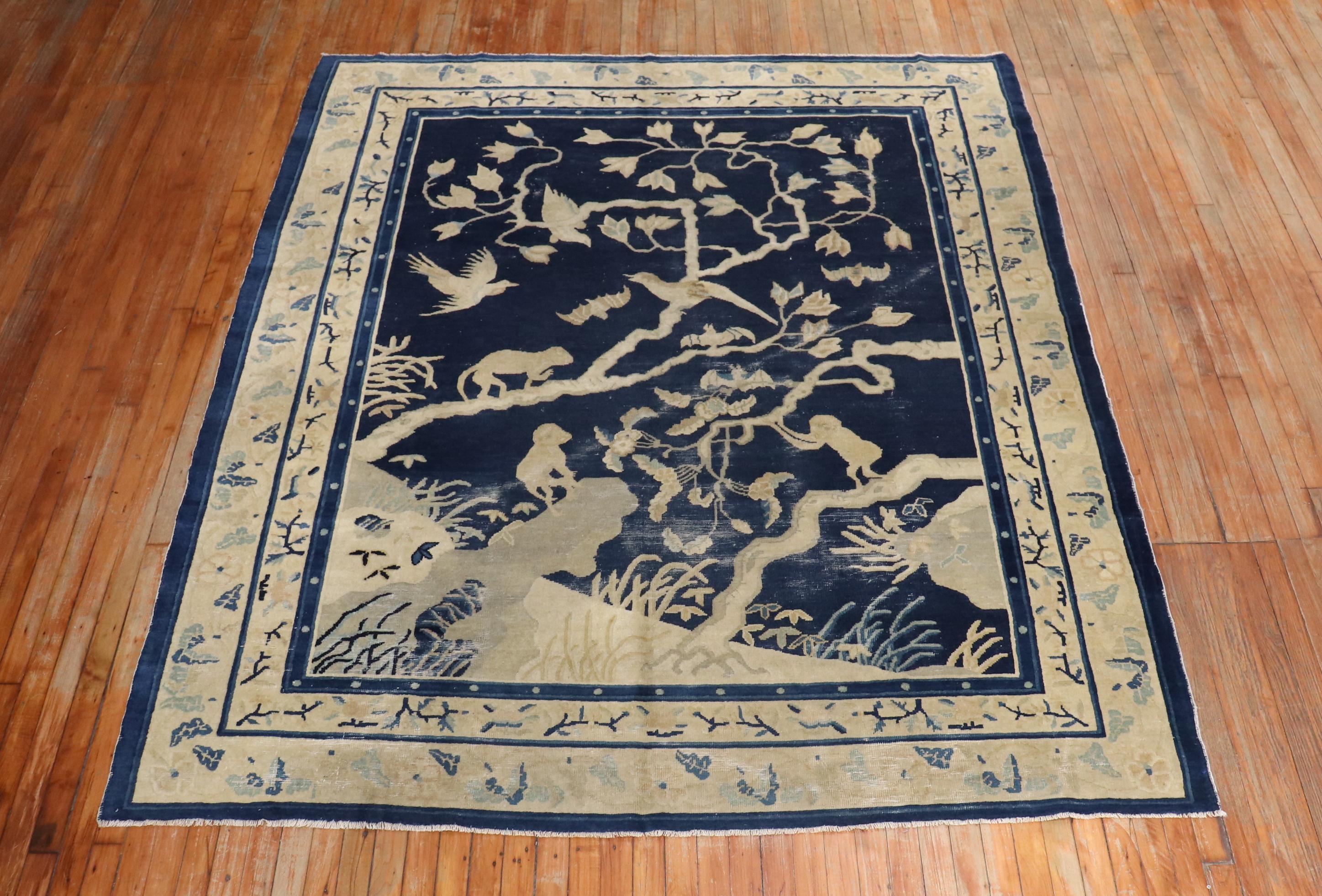 A late 19th century Chinese rug featuring 3 monkeys and some birds on a landscape scene. Navy field, beige accent colors. Some age-related wear

Measures: 7' x 8'6