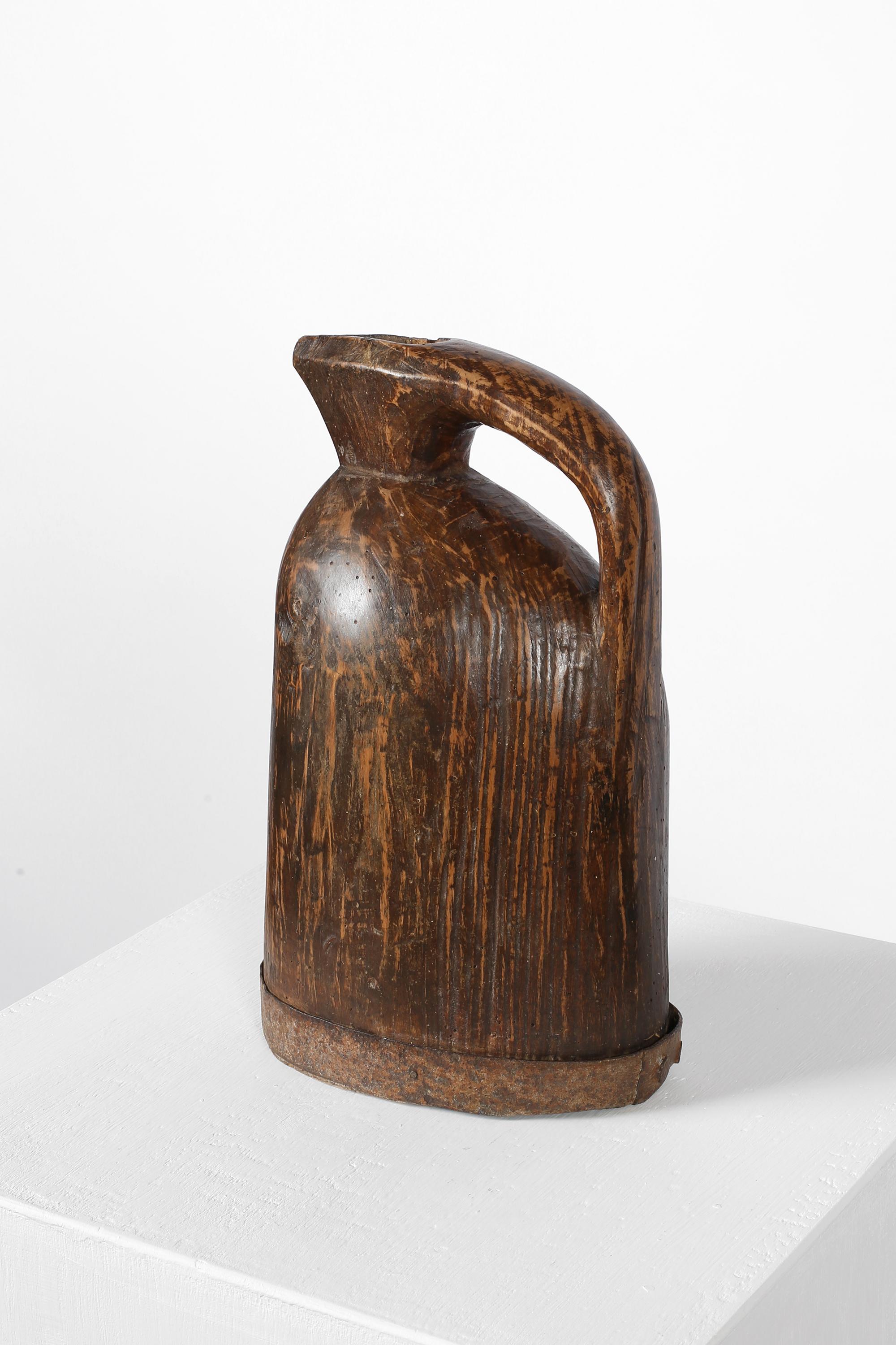 Jarra de arte popular monóxila del siglo XIX, procedente de la región de Auvernia. Tallada en una sola pieza de madera con correa de metal patinado en la base. Francés, c. 1850.