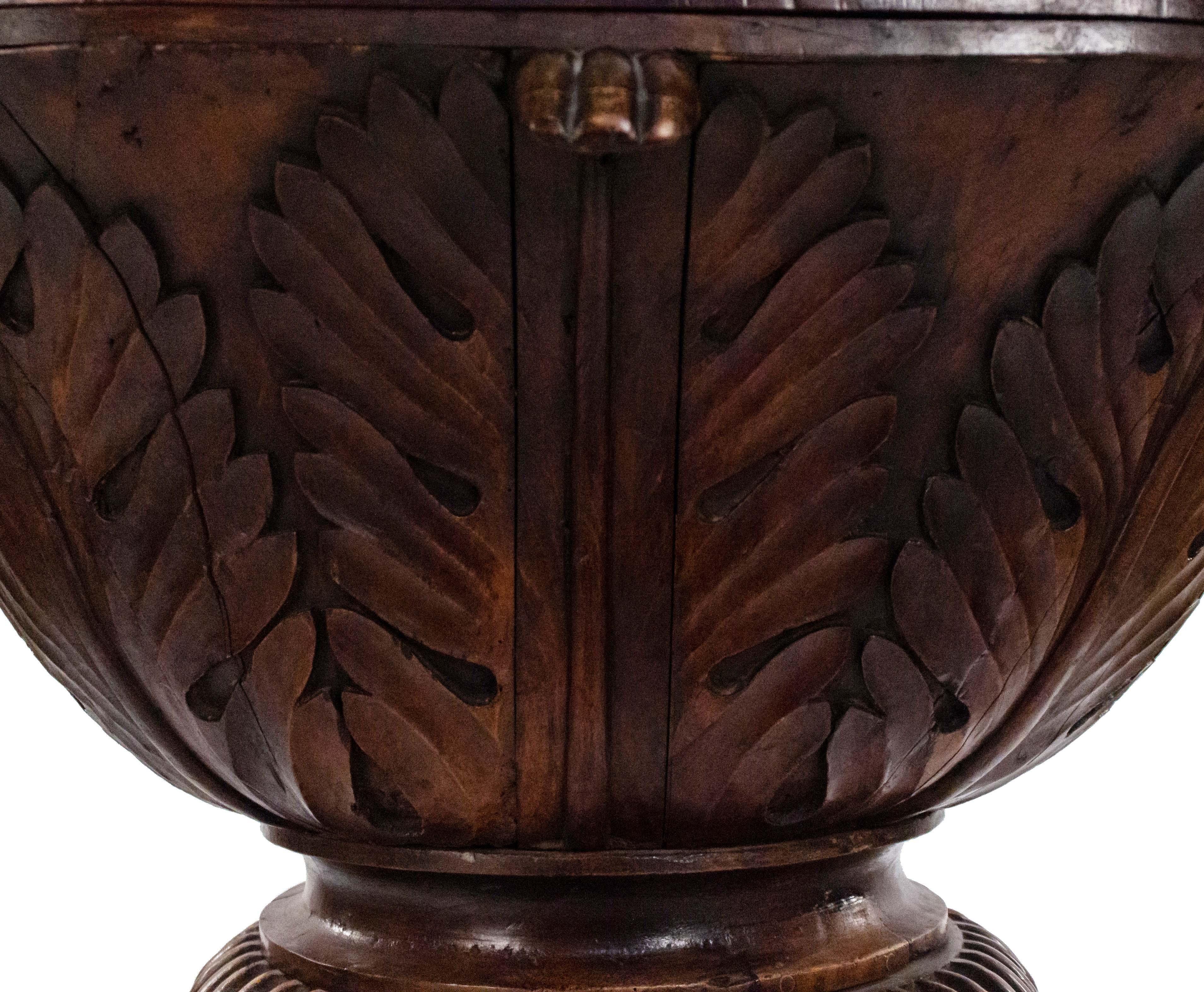 Monumental continental (19th century) carved walnut standing oval jardinière in the shape of a fluted cup with vegetal motifs. Interior lined in copper.