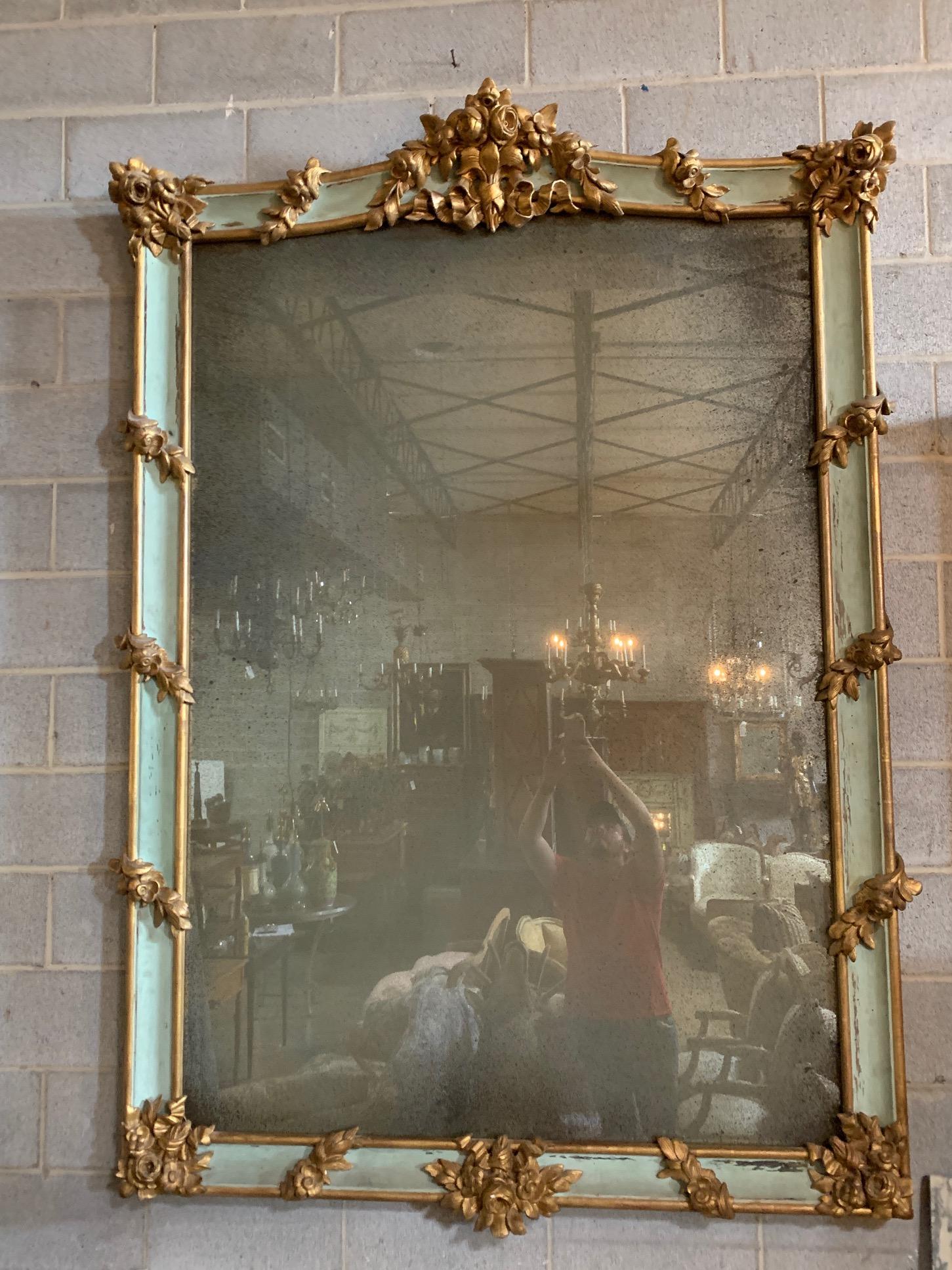 A 19th century French painted and parcel gilt mirror with beautiful elements is realized in carved and giltwood.

The style is Napoleon III, the frame is 19th century with a newer antiqued mirror. The carved wood frame is decorated with high