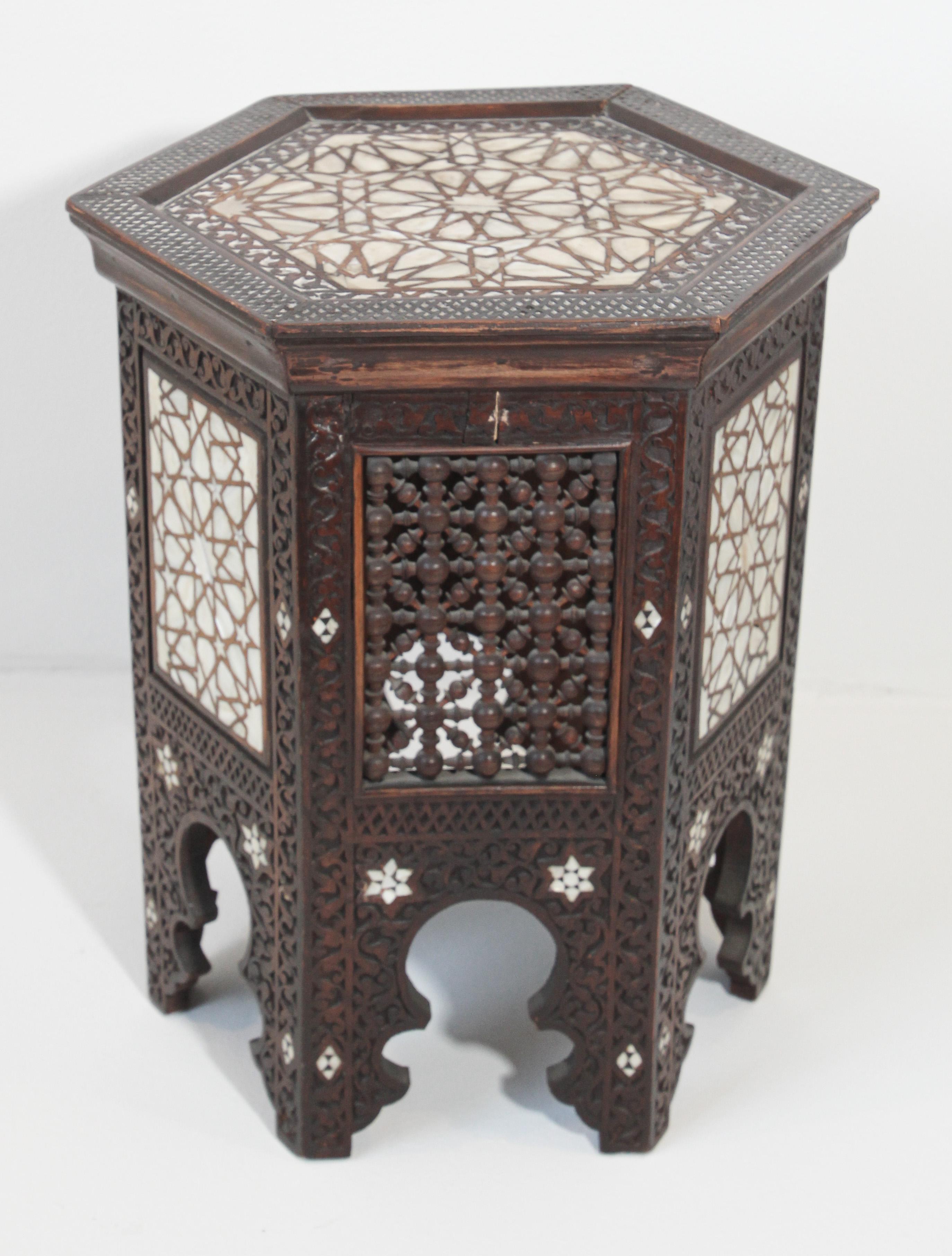 Antique 19th century Middle Eastern Moorish mother-of-pearl inlaid side table.
Hexagonal hardwood side table with mother-of-pearl inlay throughout in geometric Moorish designs.
This table has alternating side panels of white mother inlay and the