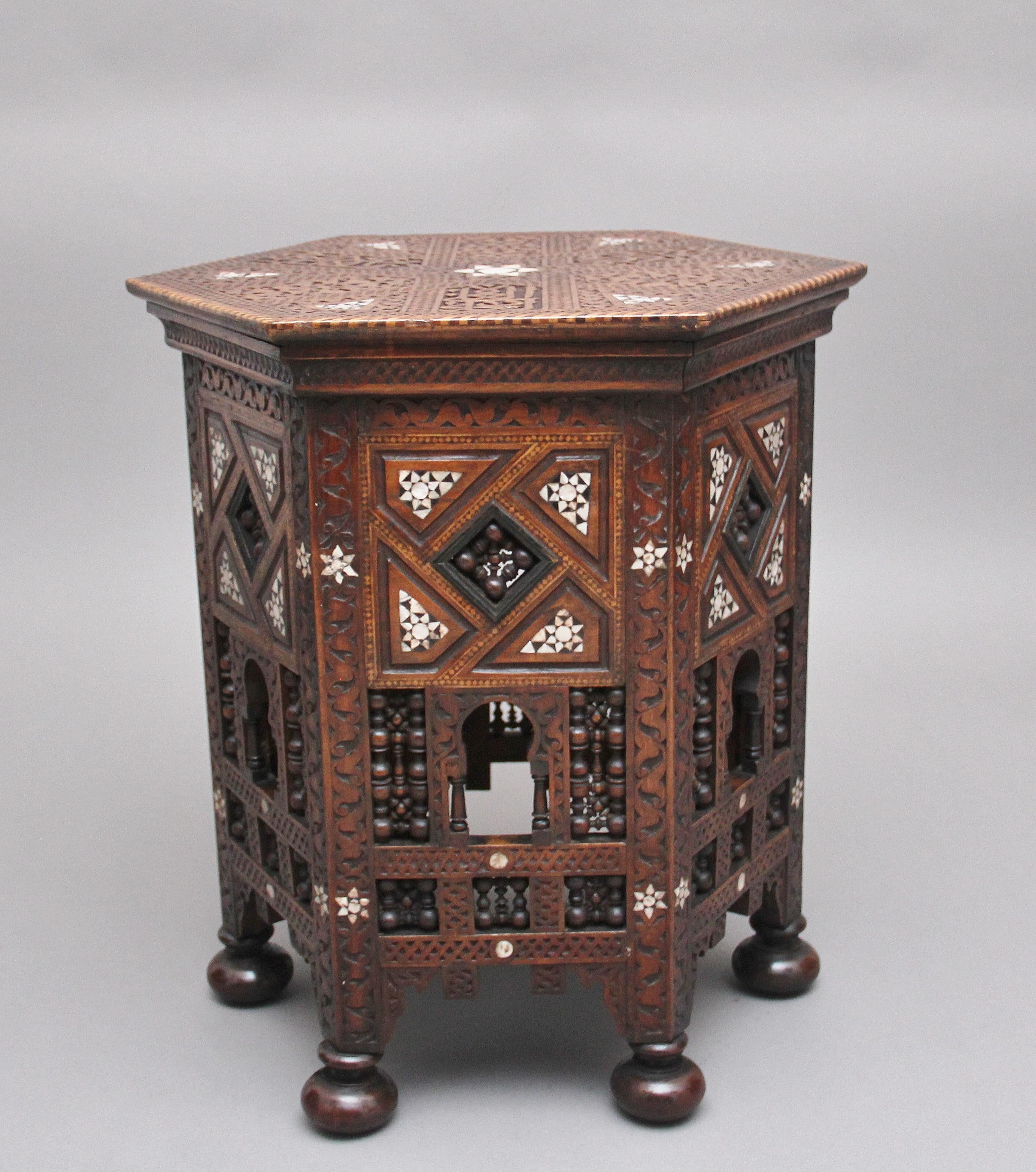 A highly decorative 19th century Moorish occasional table by Liberty & Co, the hexagon shaped top with carved Moorish design with star decoration at the centre, the edge of the top having chequered decoration, each side of the table is in keeping
