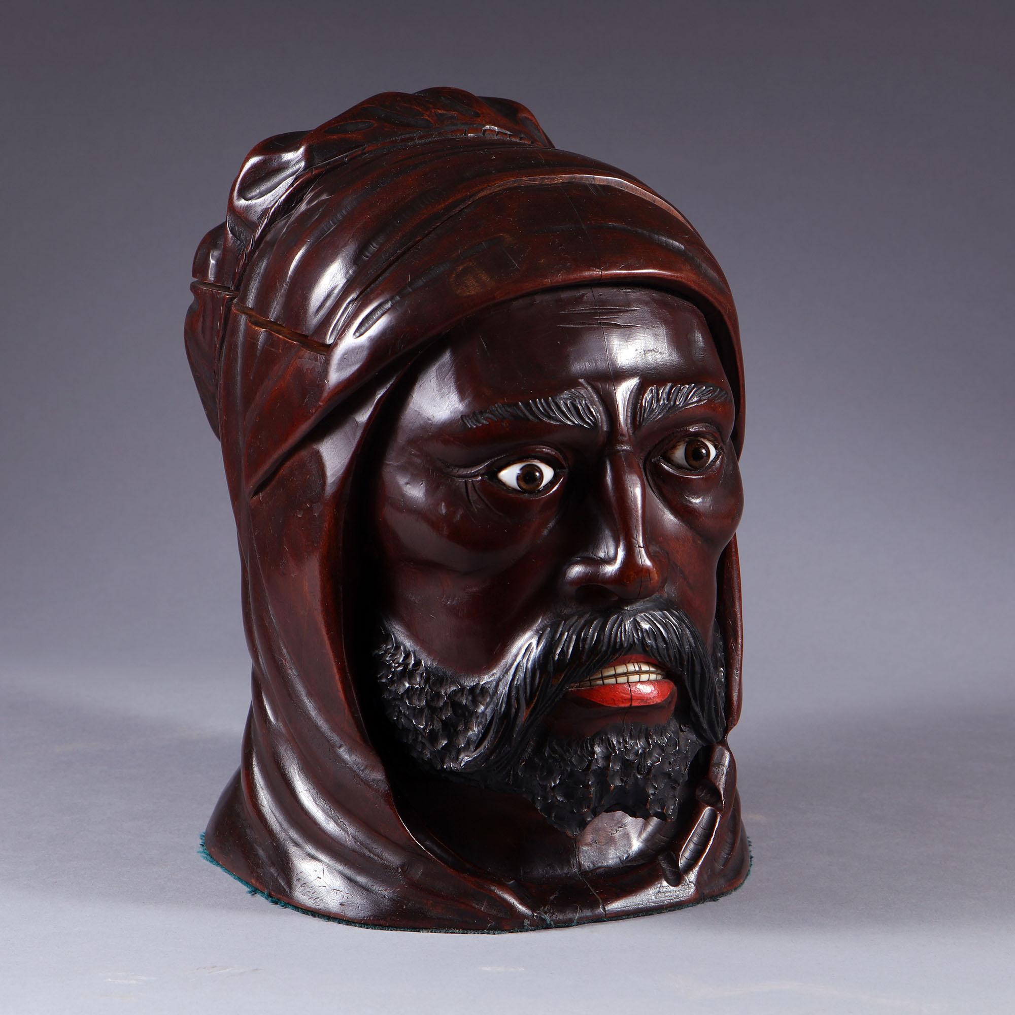 A 19th century Moor’s head carved and painted tobacco jar, with brass hinged lid and brass inner, the head carved with considerable flair, imbued with the fierce strength and mystery of the East. Possible Black Forest.
