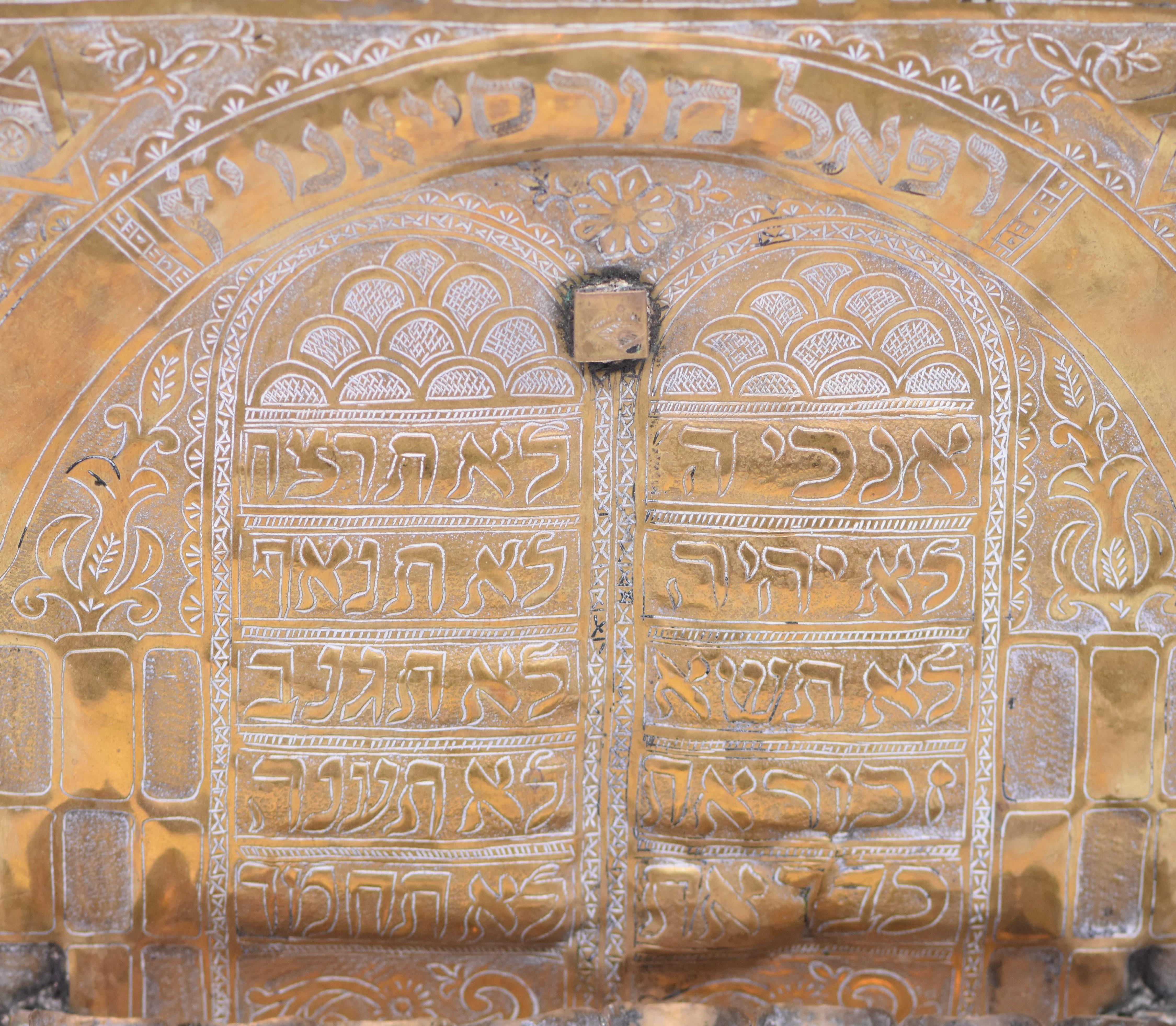 Lampe de Hanukkah en laiton martelé et gravé à la main, Maroc, 19e siècle, avec des fontaines à huile à becs pincés fixées à la plaque arrière. Un décor découpé à la main en forme de feuilles montre des feuilles de laiton martelé gravées pour