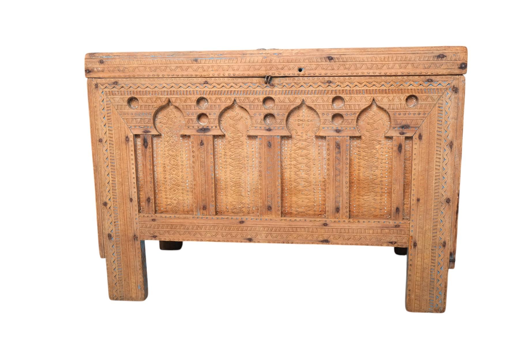 A stunning 19th century Moroccan dowry chest hand-carved from solid cedar wood, featuring a richly detailed facade of Moorish horseshoe arches and geometric patterning throughout. This architectural piece showcases traditional North African