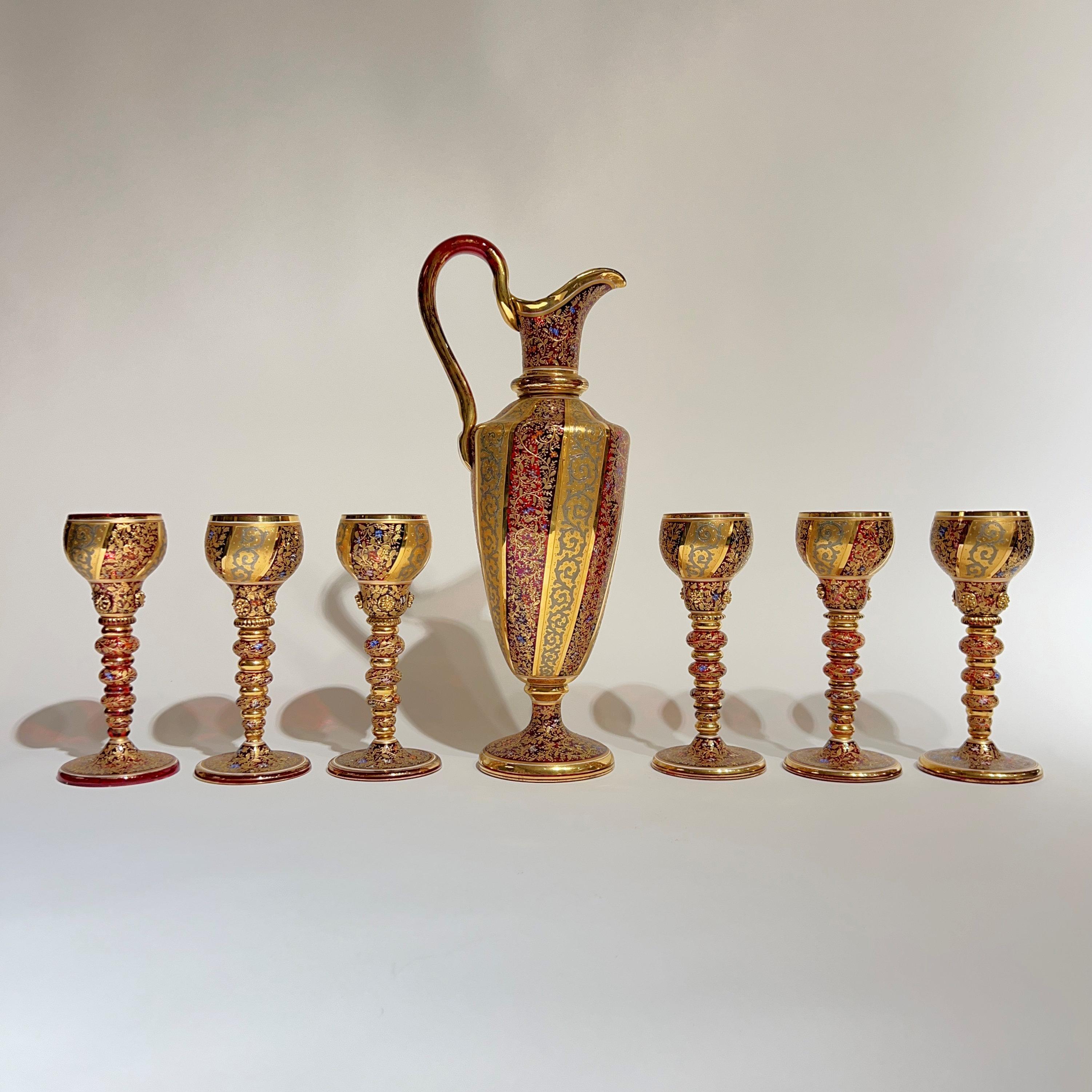 Beautiful antique (19th century) Moser Gilt and enameled Ruby Red Glass Pitcher and Wine Glass Set,  including pitcher (16 1/2 inch height) and six matching water or wine glasses (each 7 3/4 inches).  In excellent condition.  