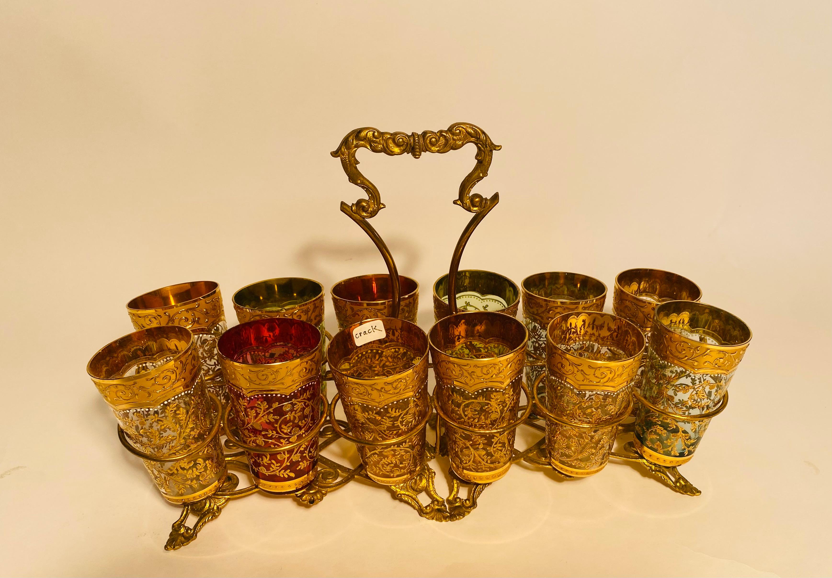 A highly decorative antique set from the European firm of Moser featuring it's signature all over raised gilt decoration on blown crystal. Each piece sits nicely in its holder and transports so easily from room to room. The caddy that holds the